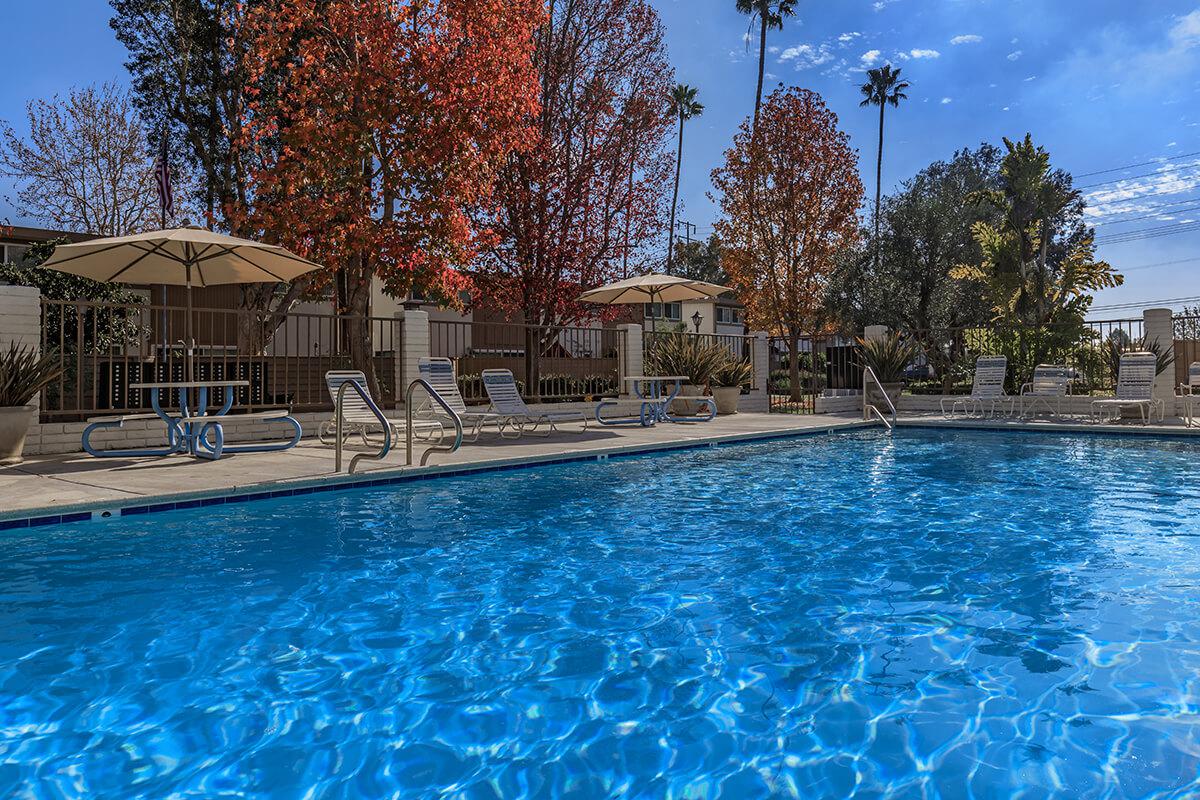 Sea Breeze Rental Townhomes pool with tables and umbrellas