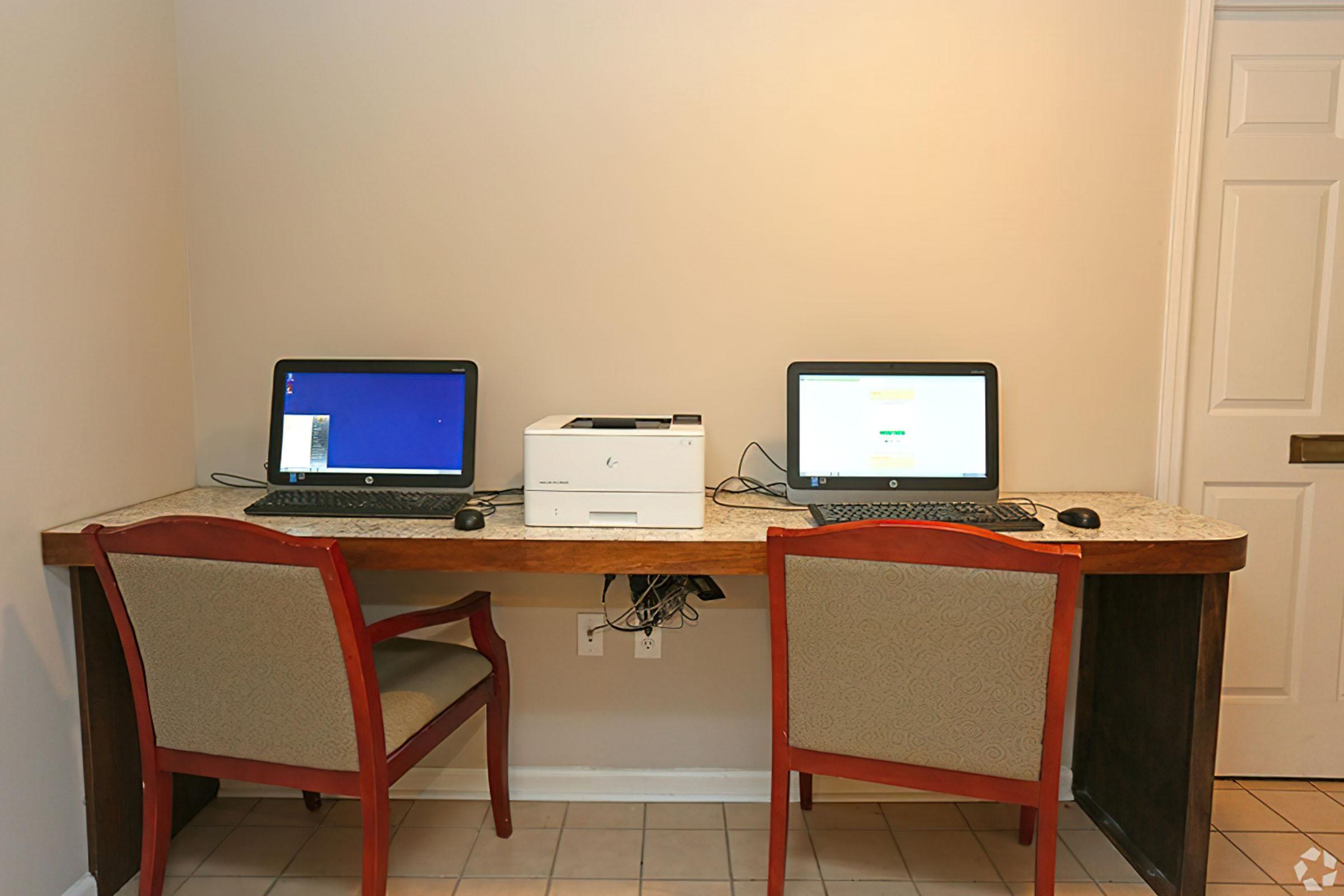 a desk with a laptop computer sitting on top of a chair