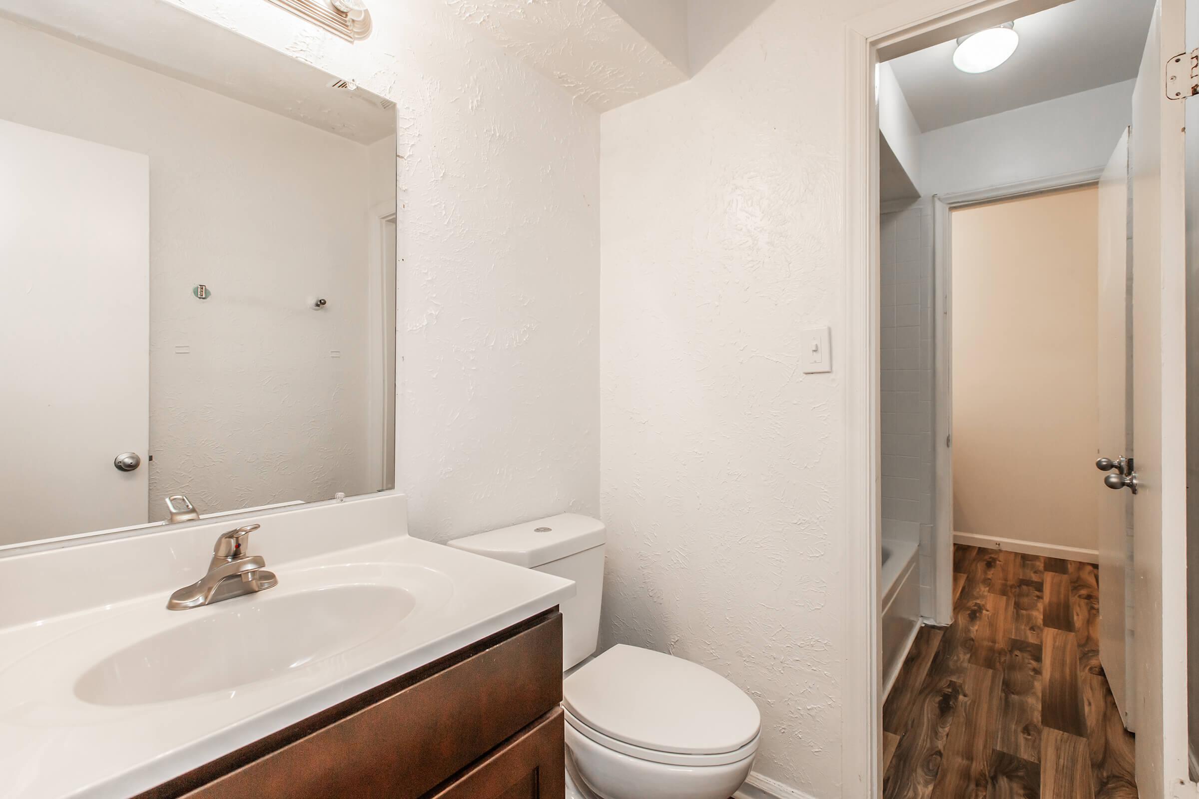 a white sink sitting under a mirror