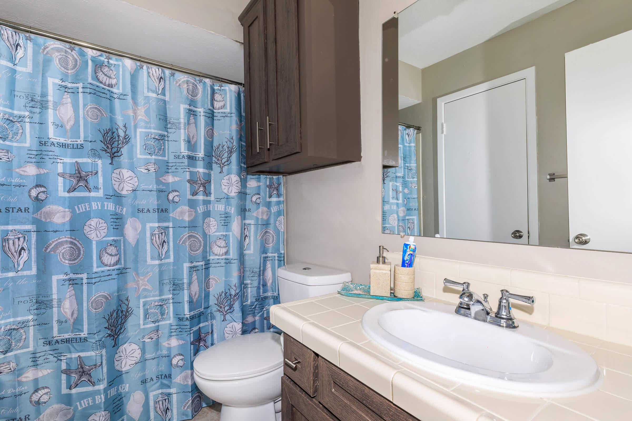 a white sink sitting under a mirror