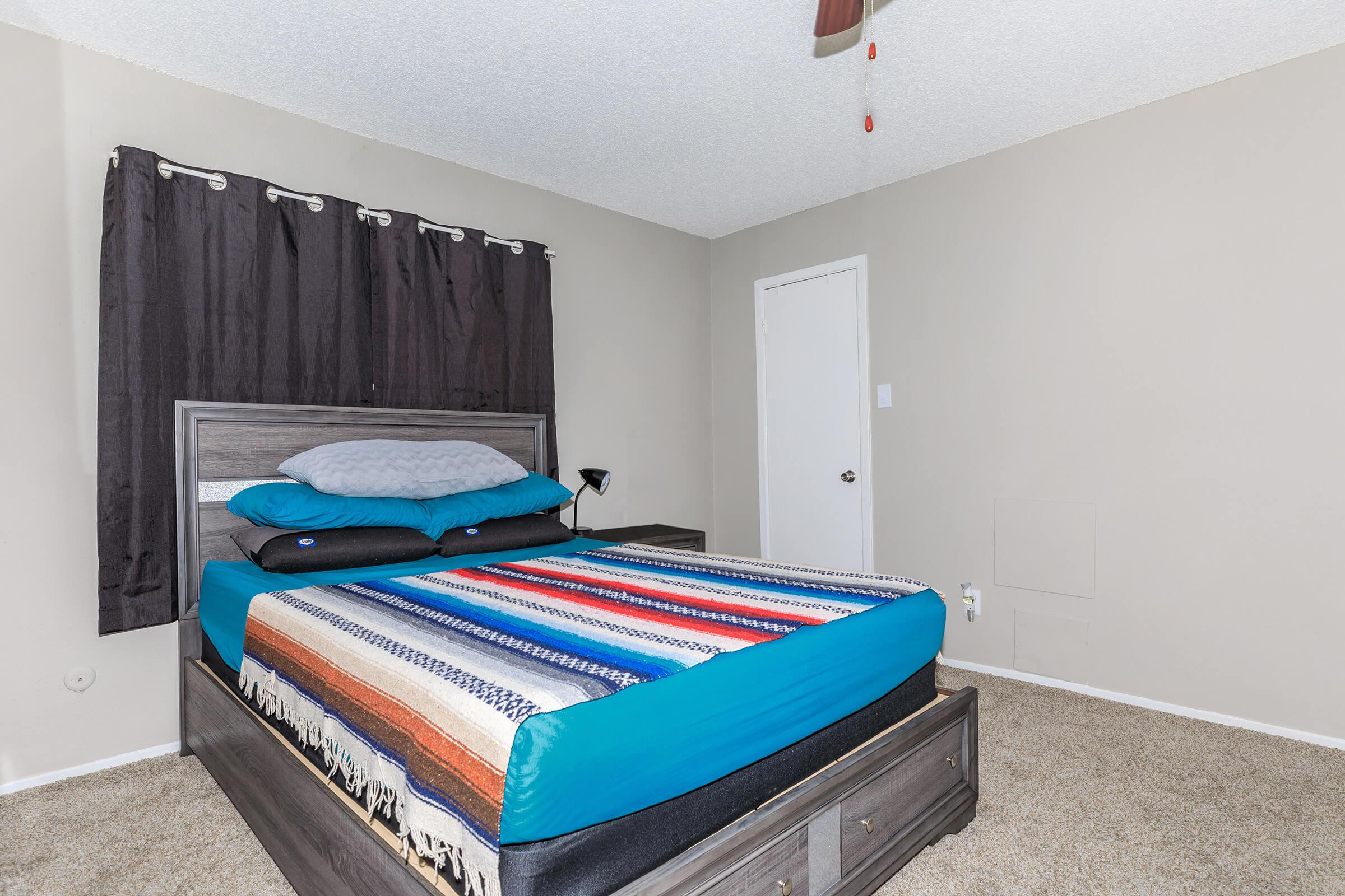 a bedroom with a bed and desk in a room