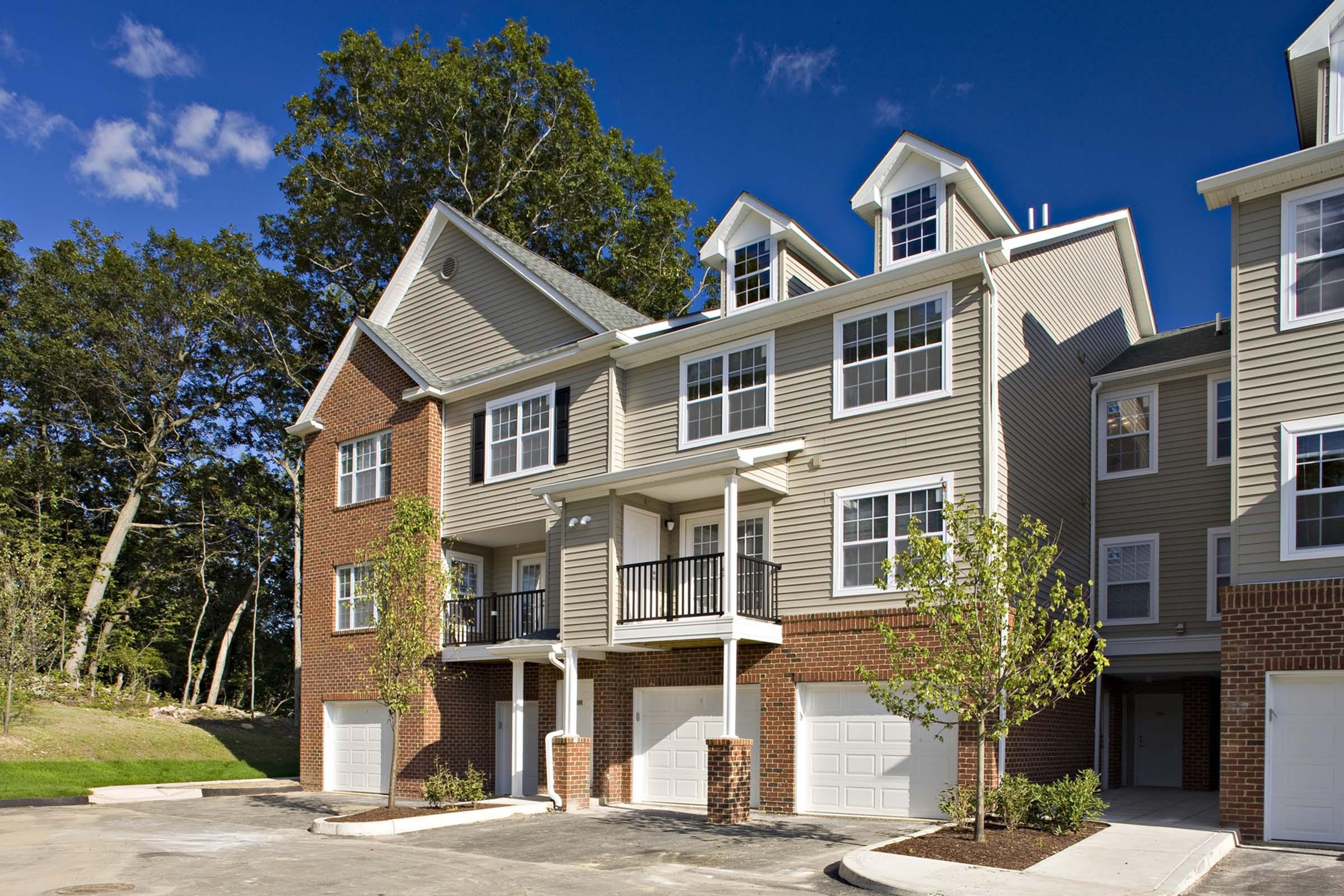 a house with trees in front of a brick building