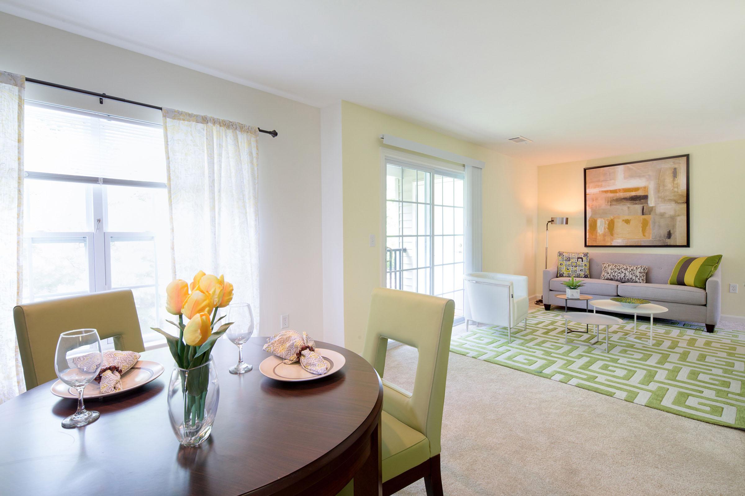 a living room filled with furniture and vase of flowers on a table