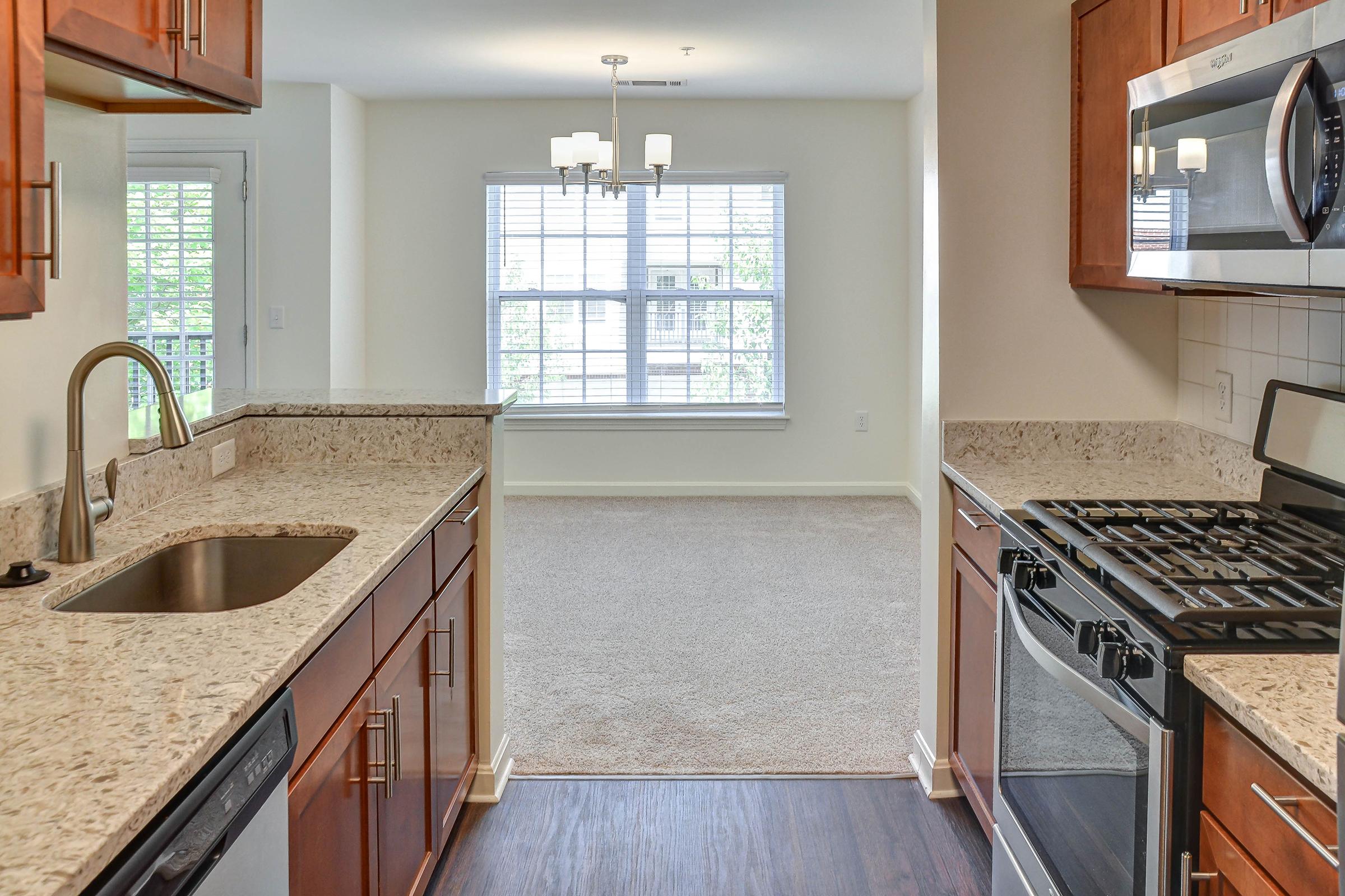 a kitchen with a stove a sink and a window