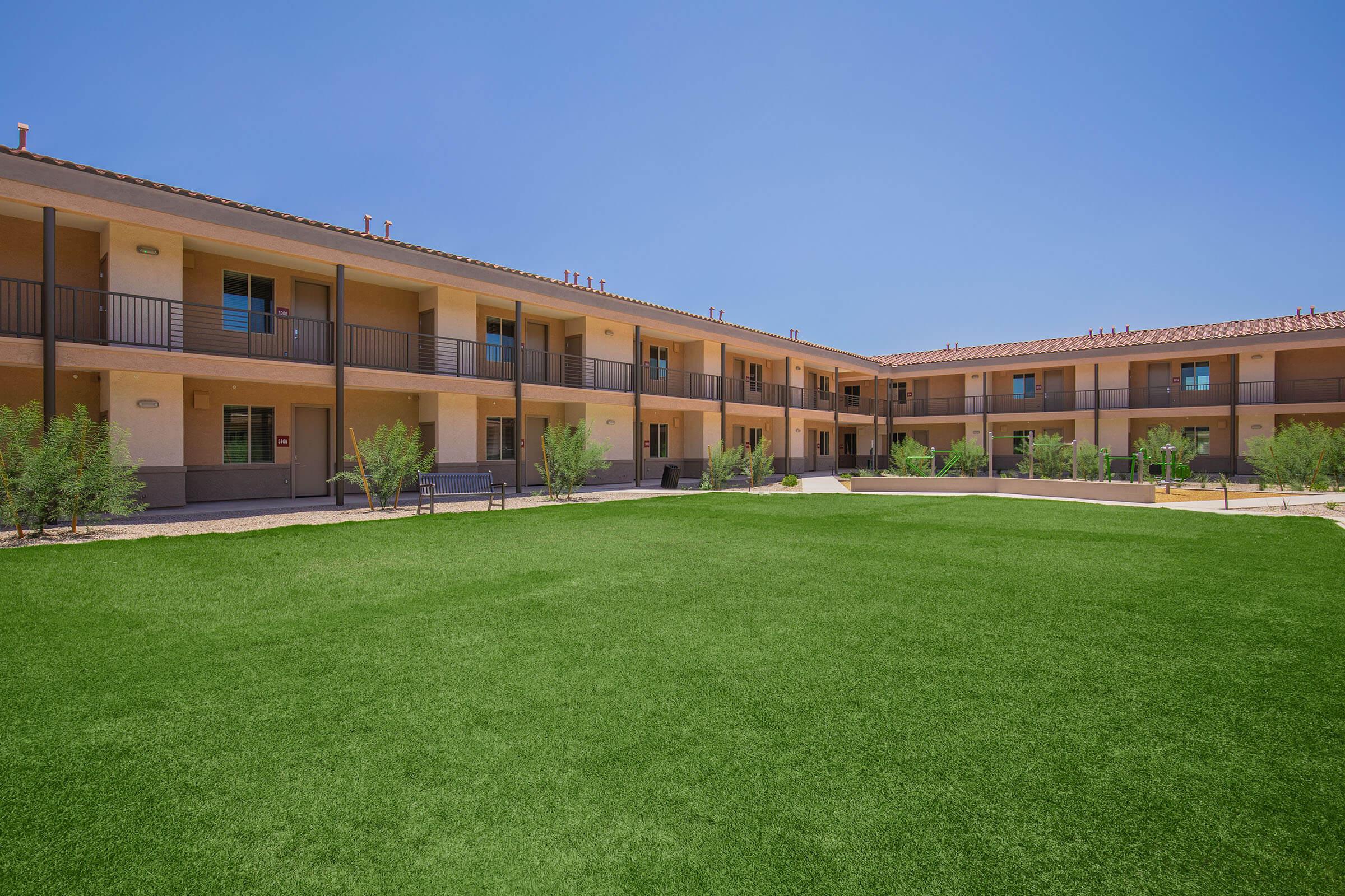 a large brick building with green grass