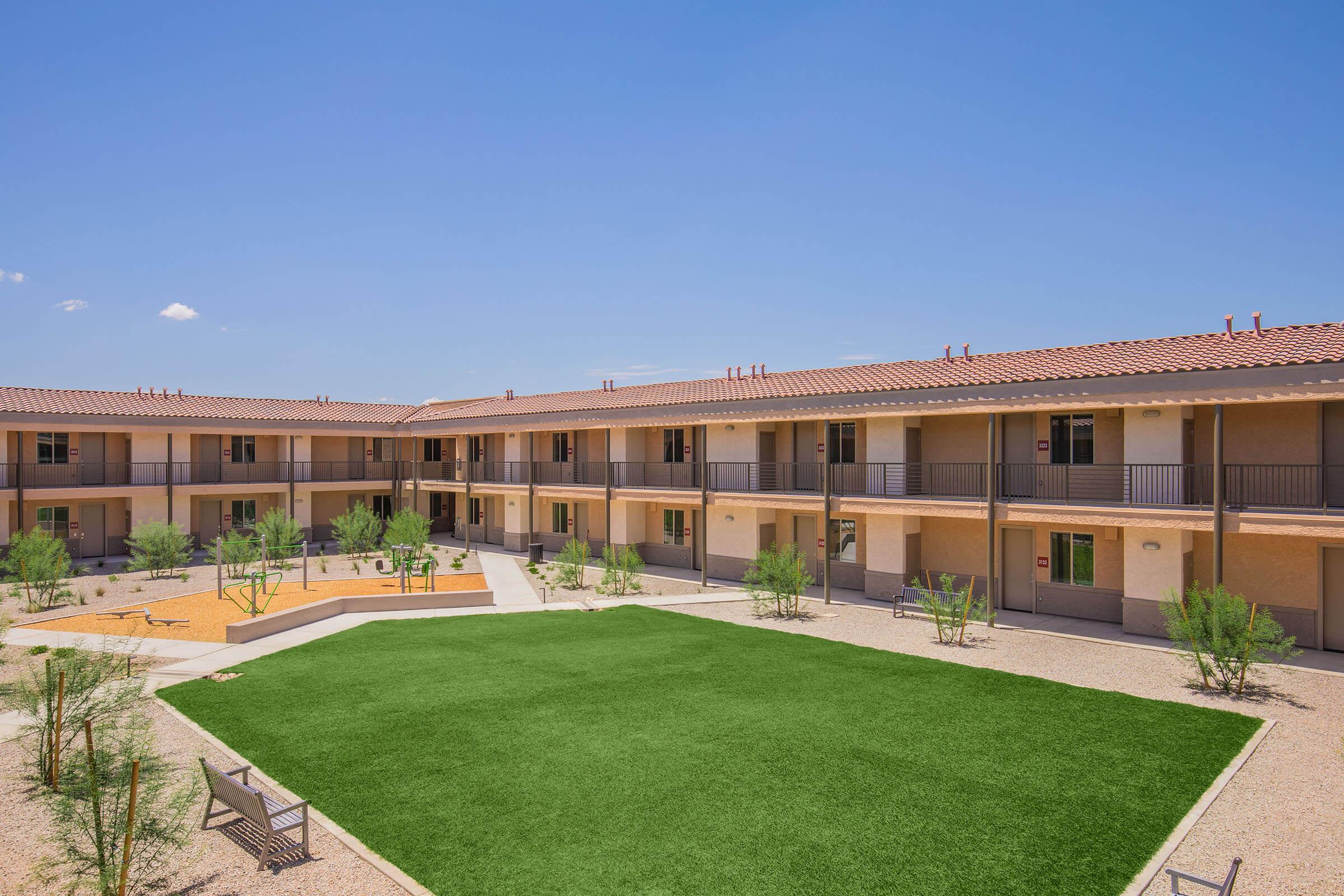 a large brick building with grass in front of a house