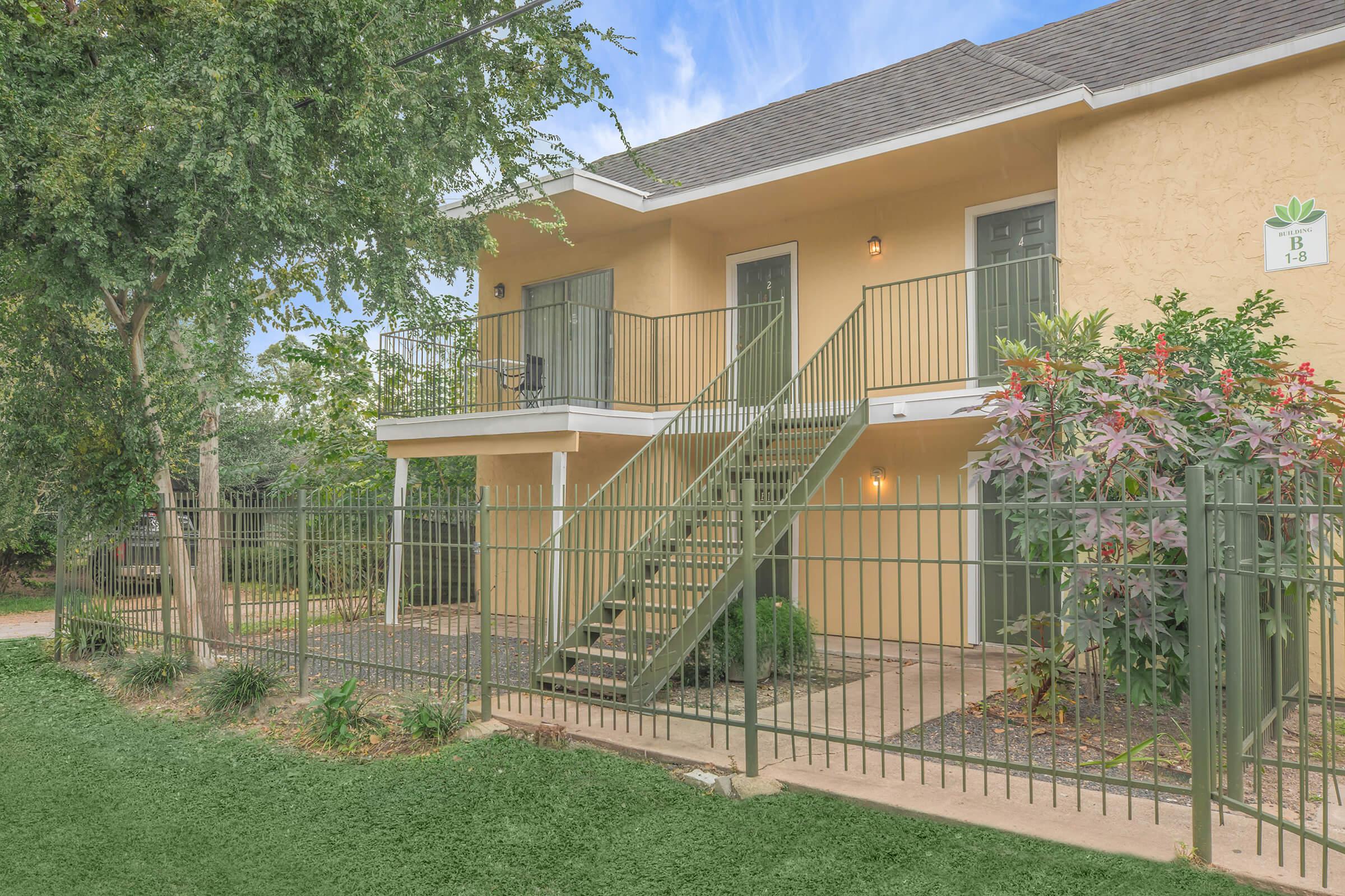 a house with a fence in front of a building