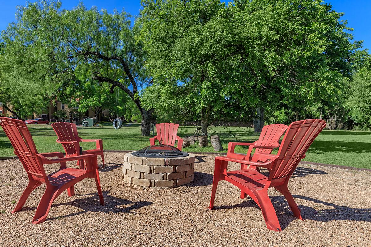 a red park bench next to a picnic table