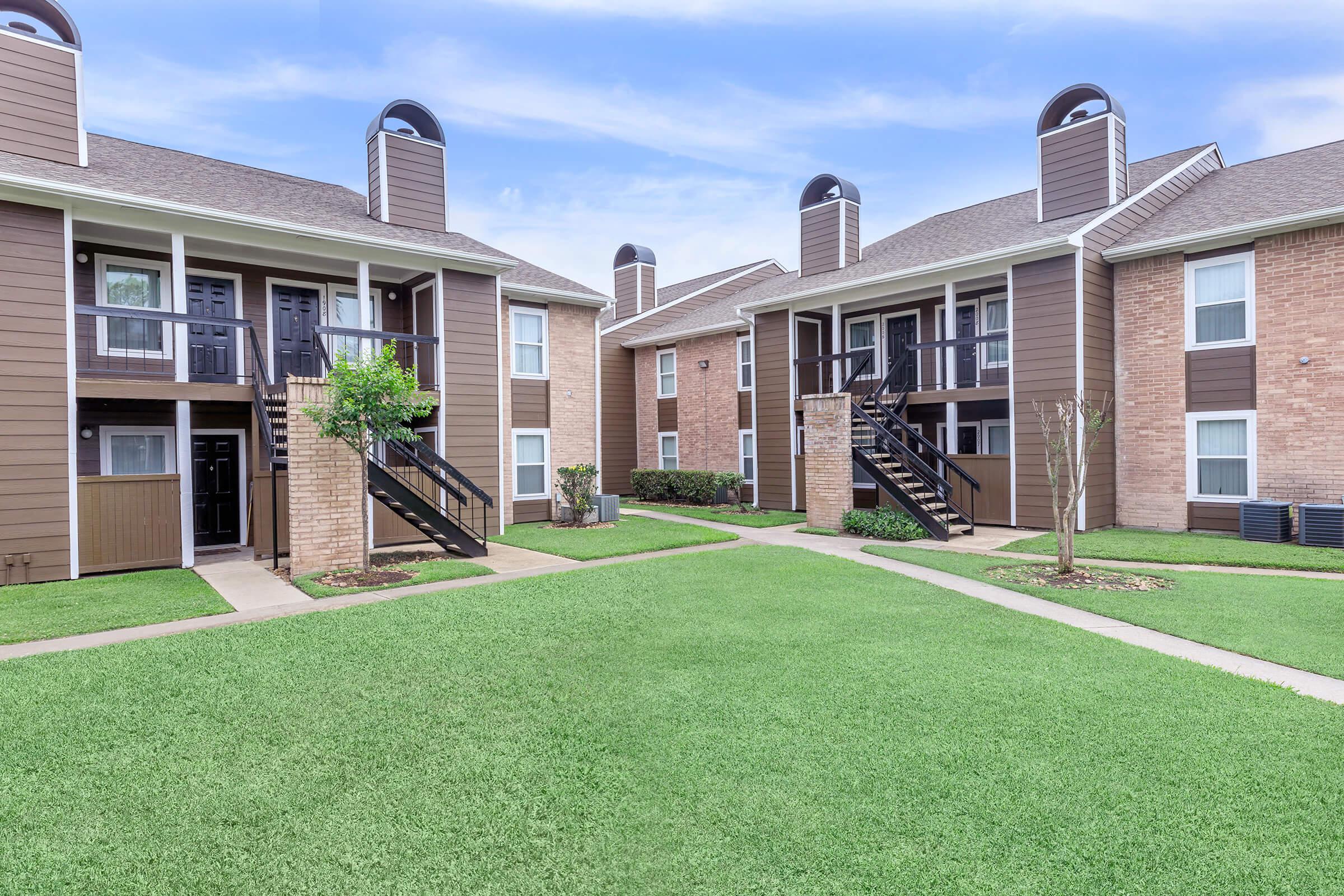 a large lawn in front of a brick building