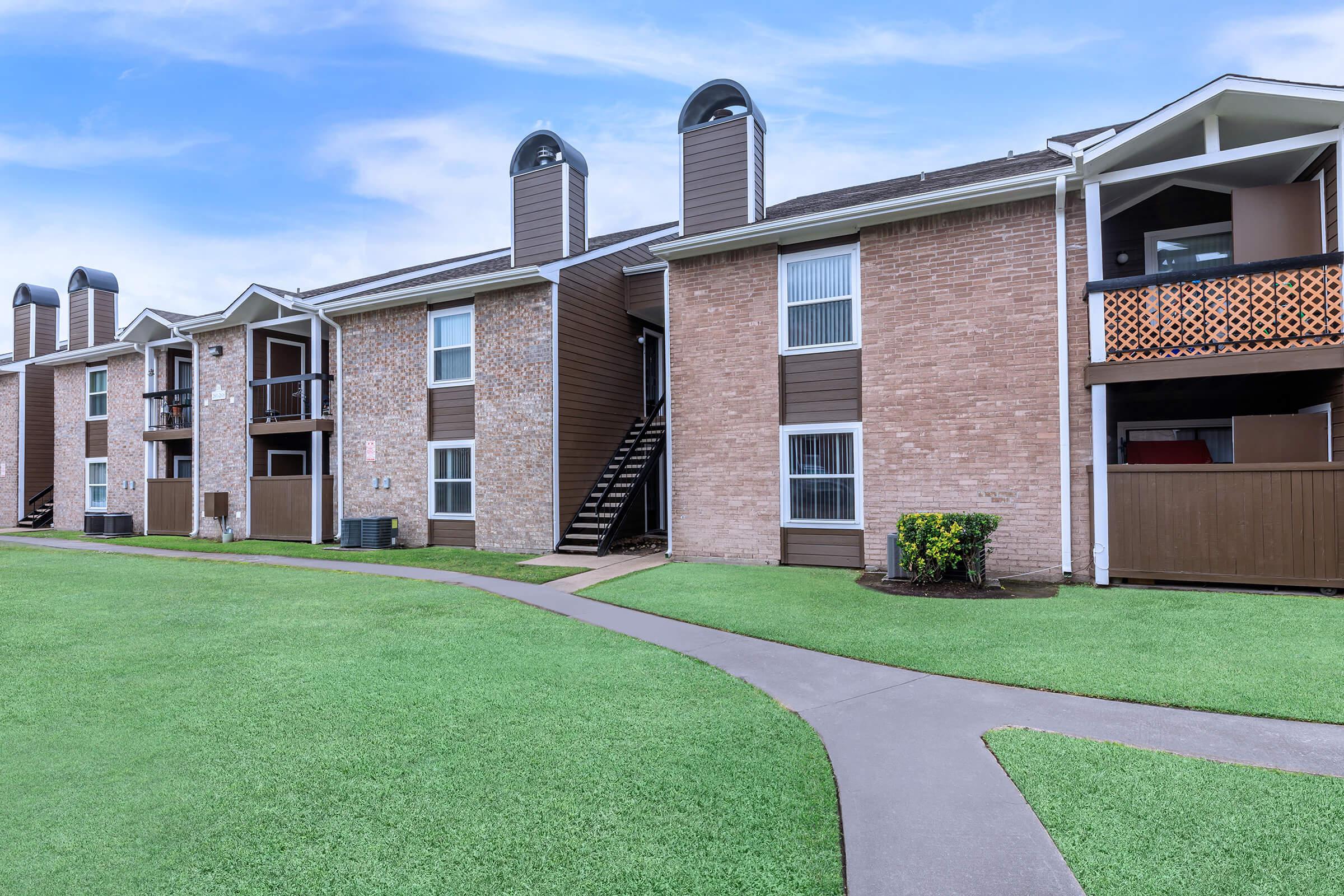 a large lawn in front of a brick building