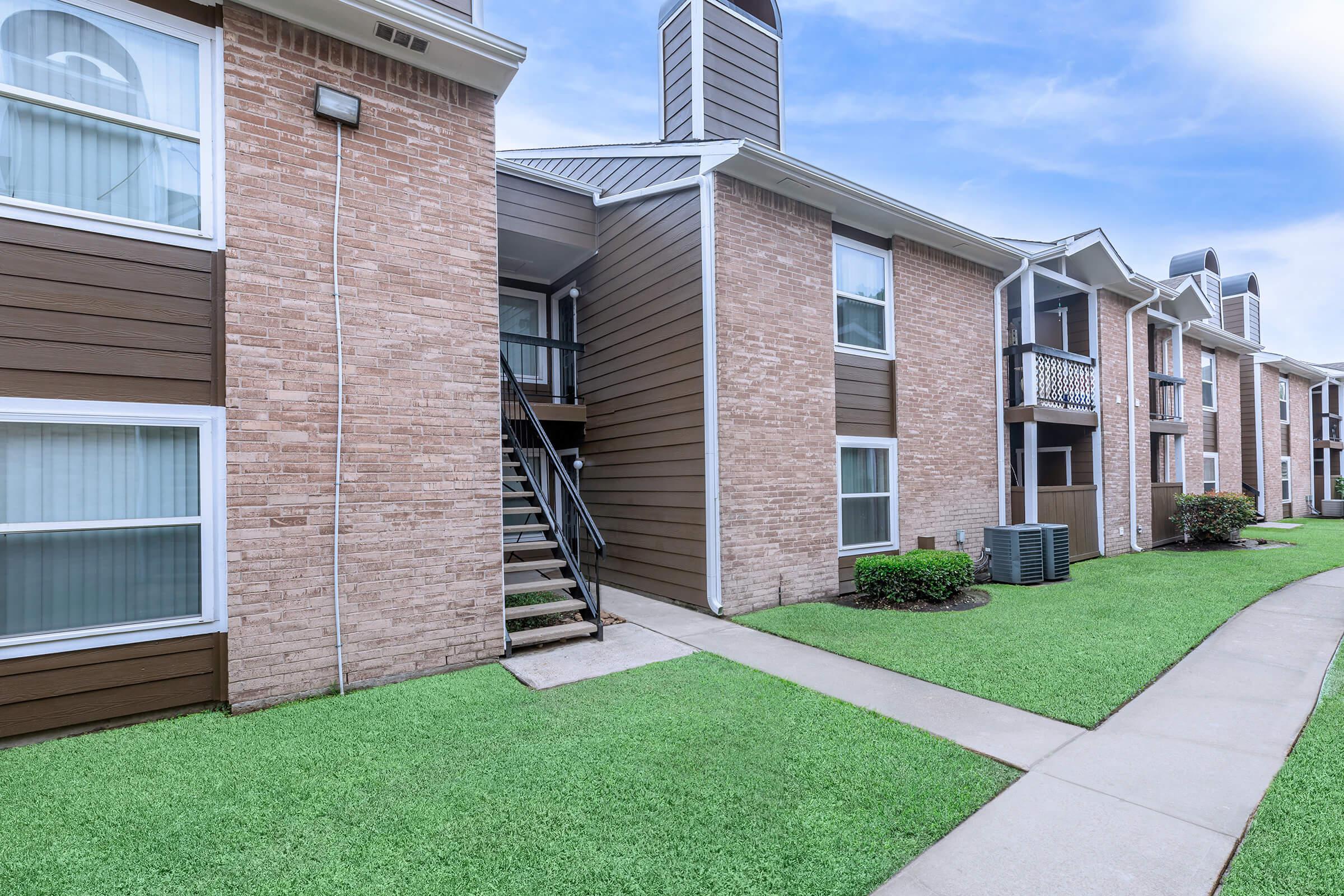 a large lawn in front of a brick building