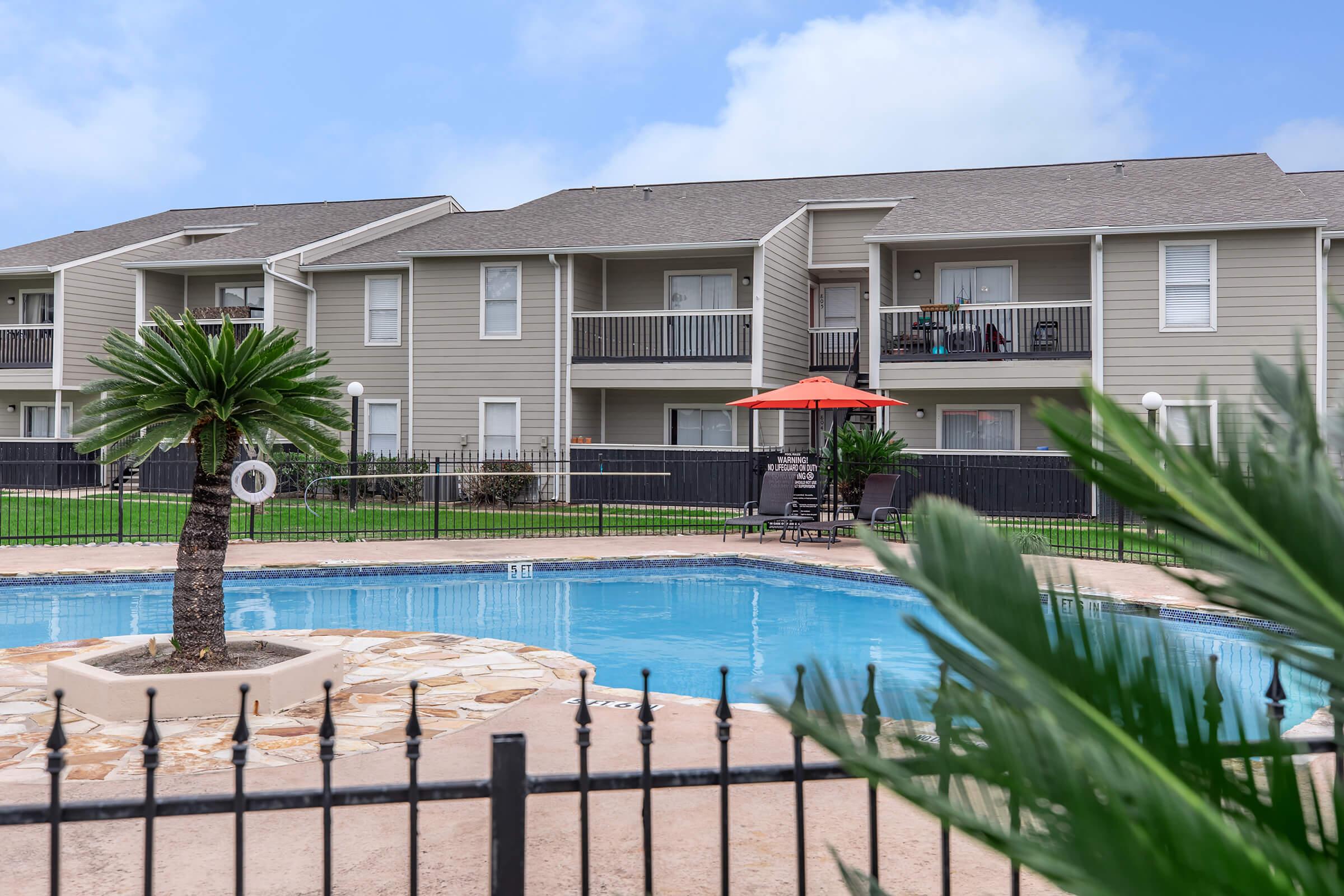 a house with a pool in front of a fence