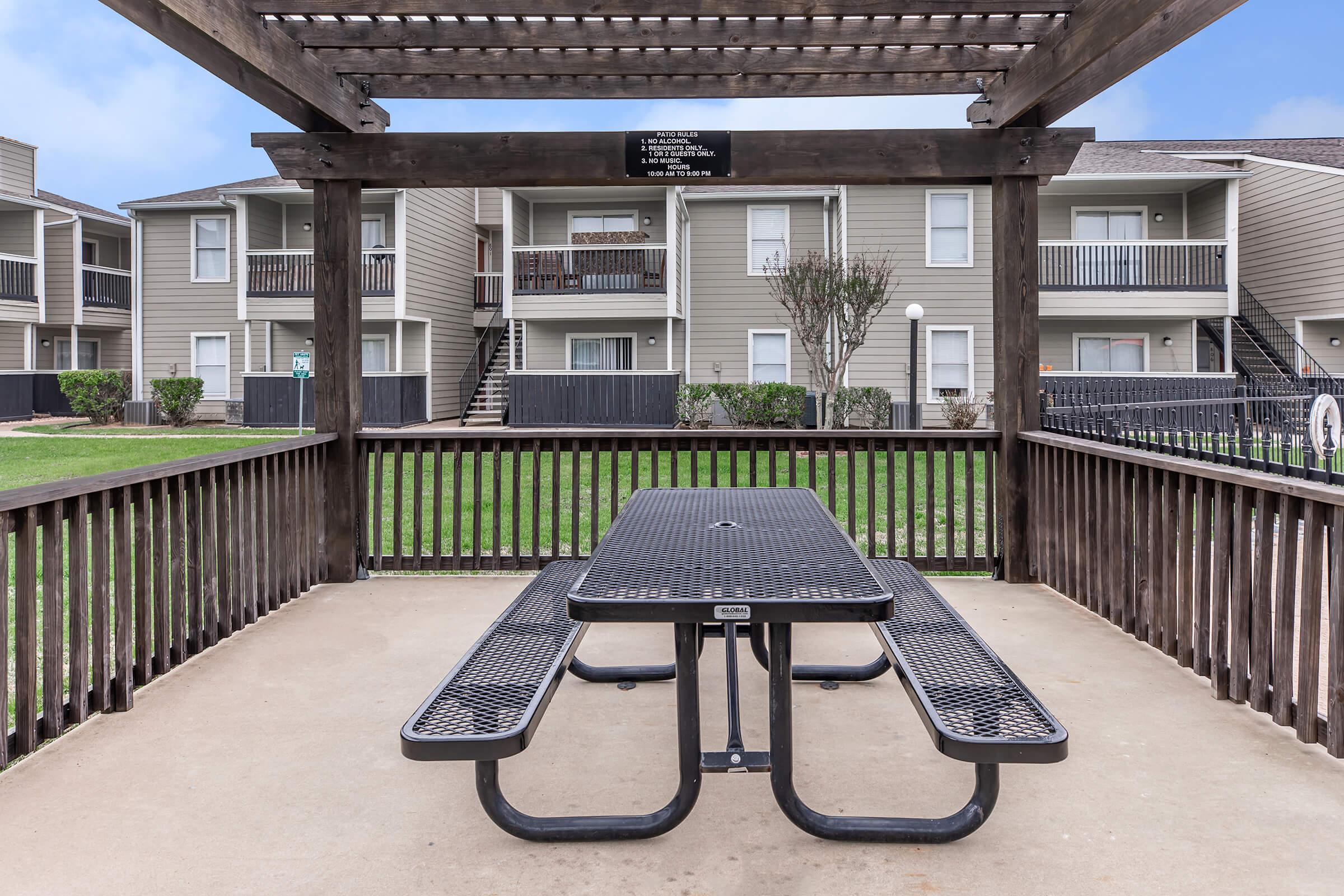 an empty park bench next to a building