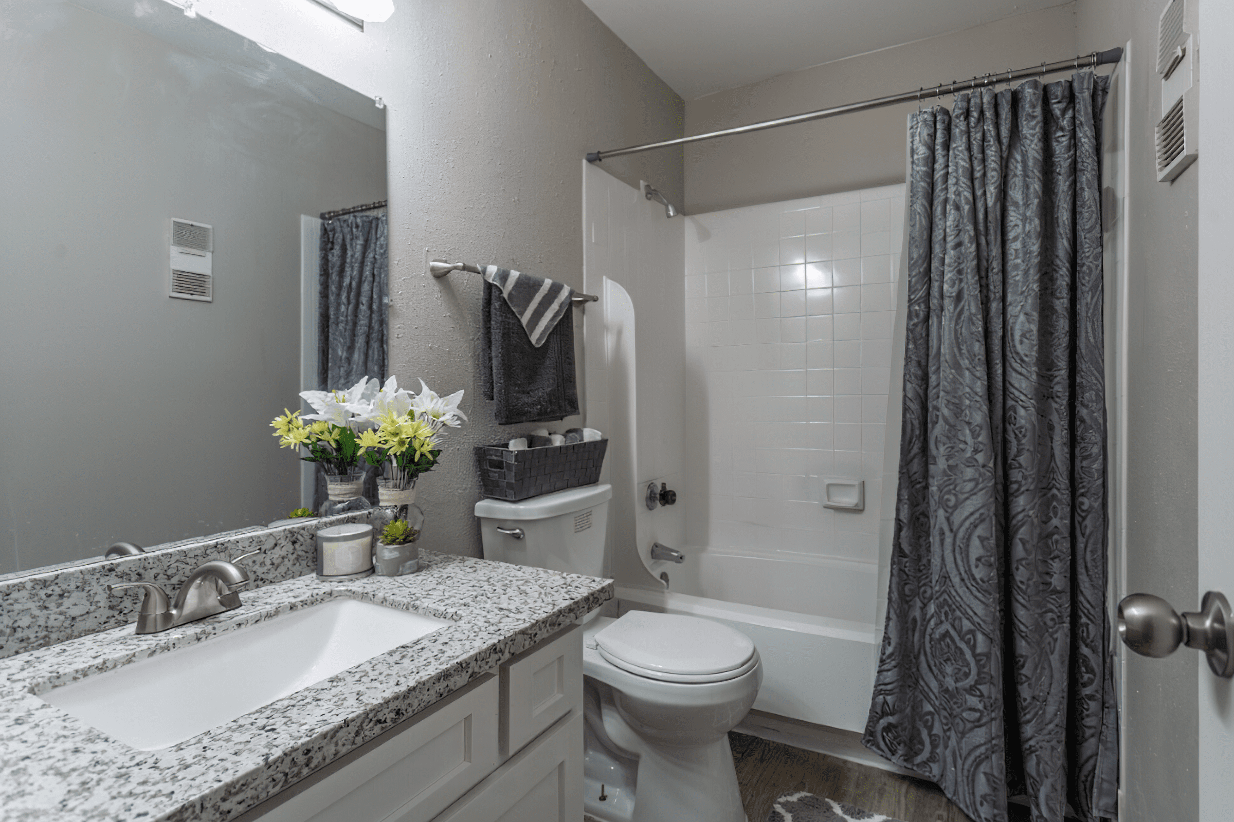 a room with a sink mirror and shower curtain