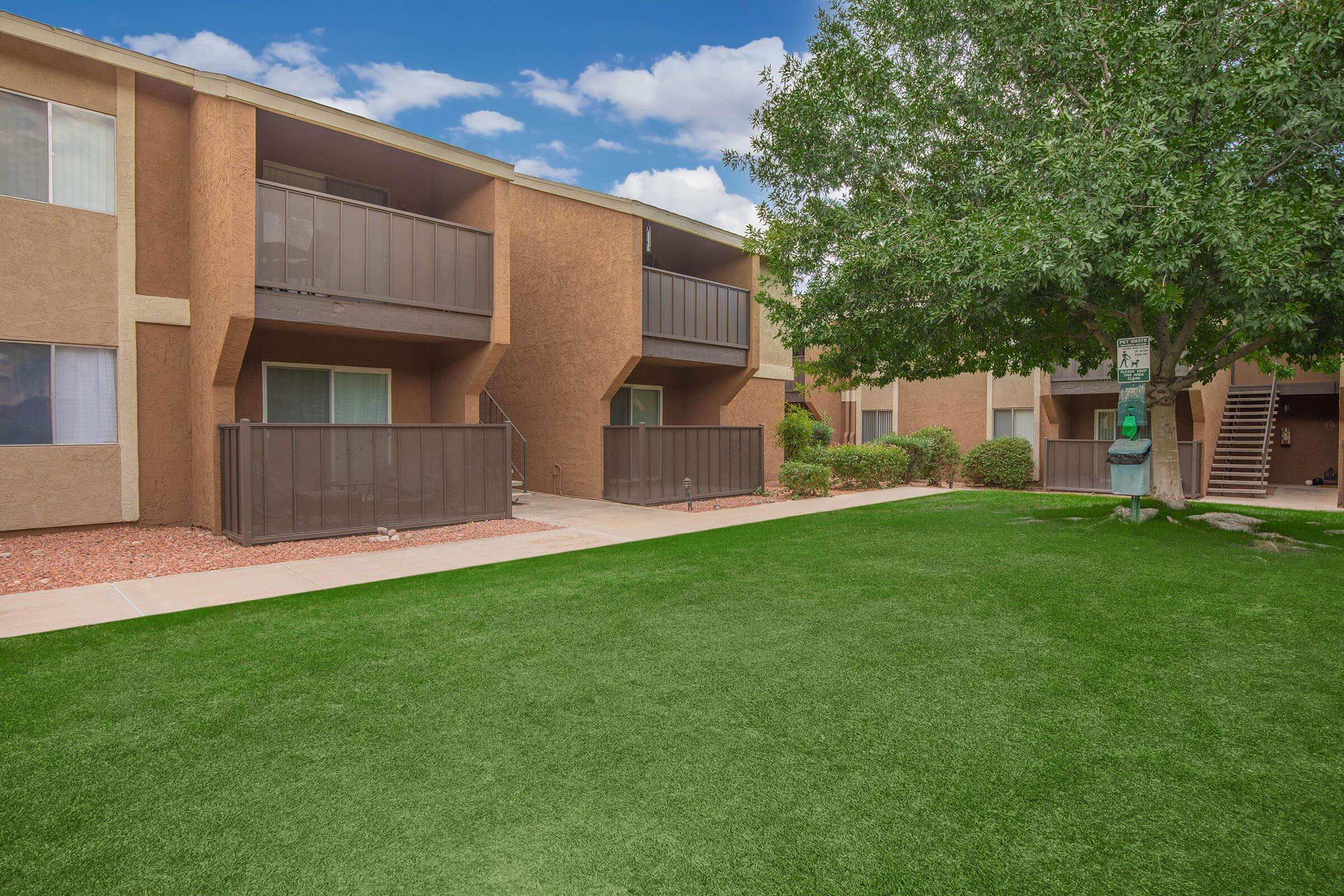 a large lawn in front of a brick building