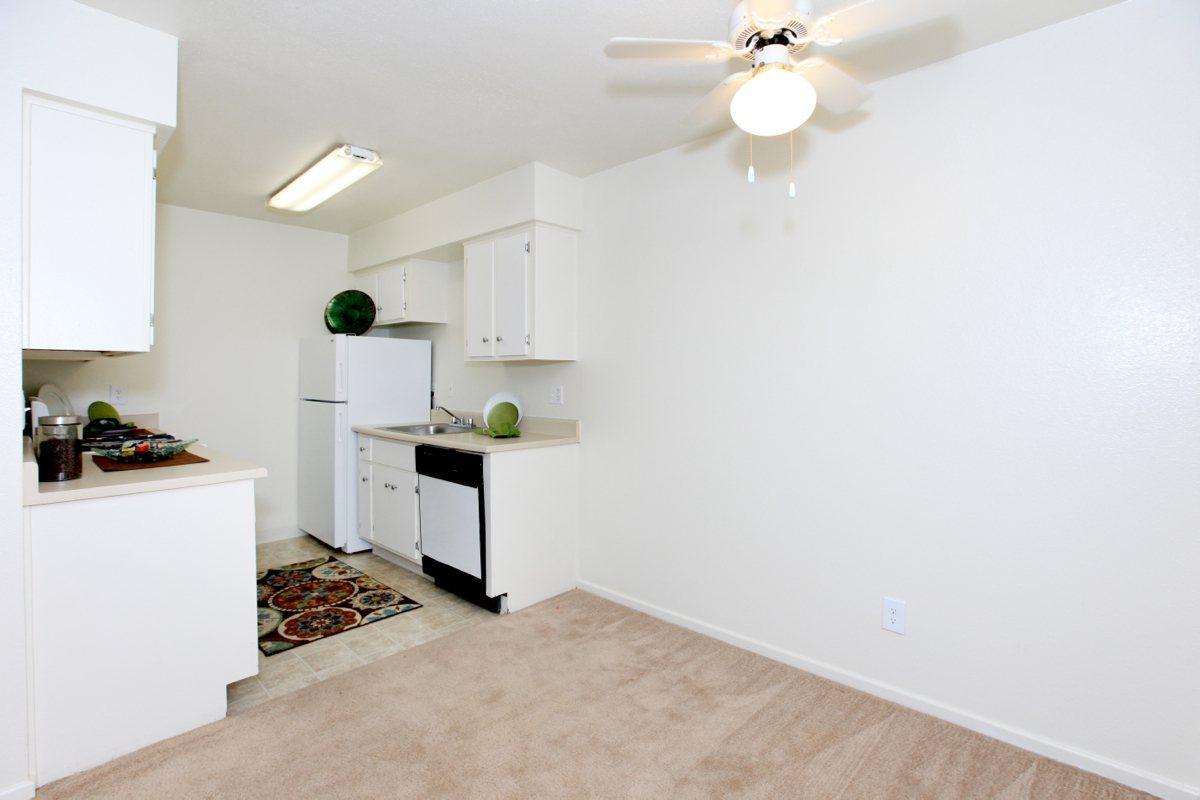 a kitchen with a white refrigerator freezer sitting in a room