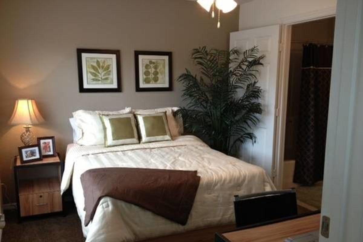 a bedroom with a bed and desk in a room