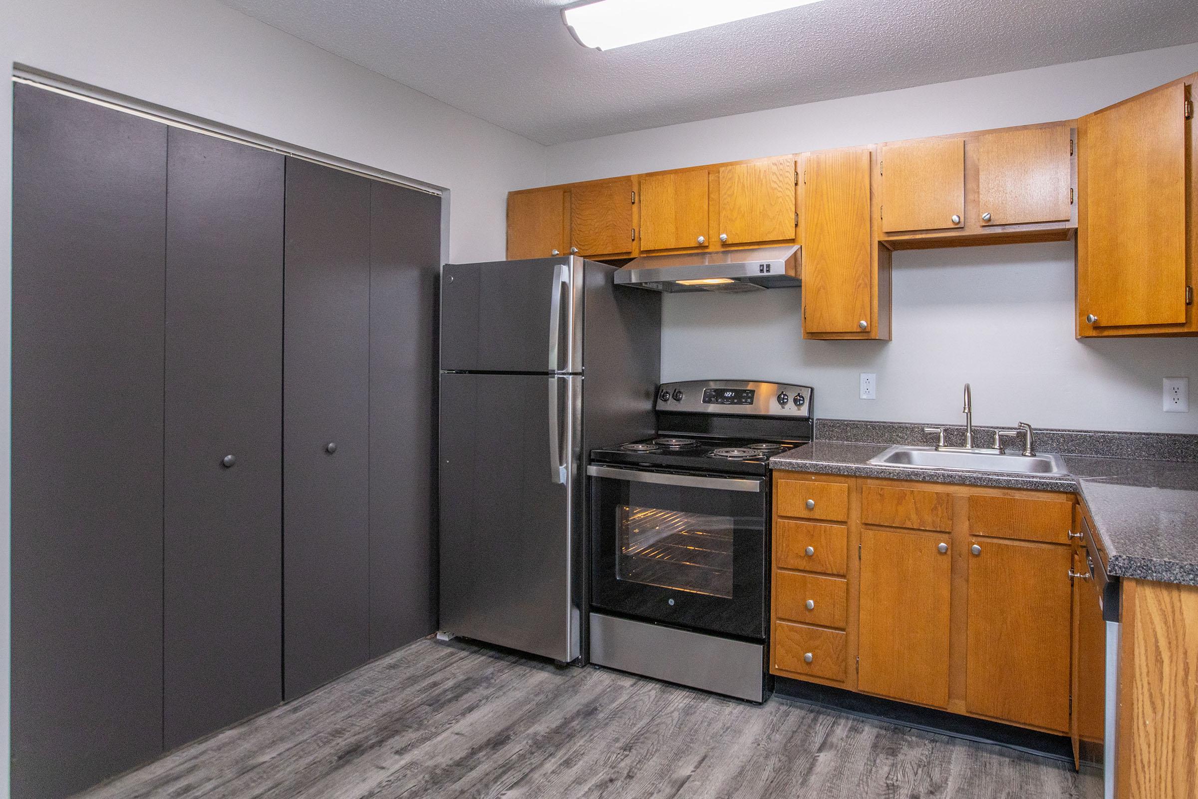 a large kitchen with stainless steel appliances and wooden cabinets