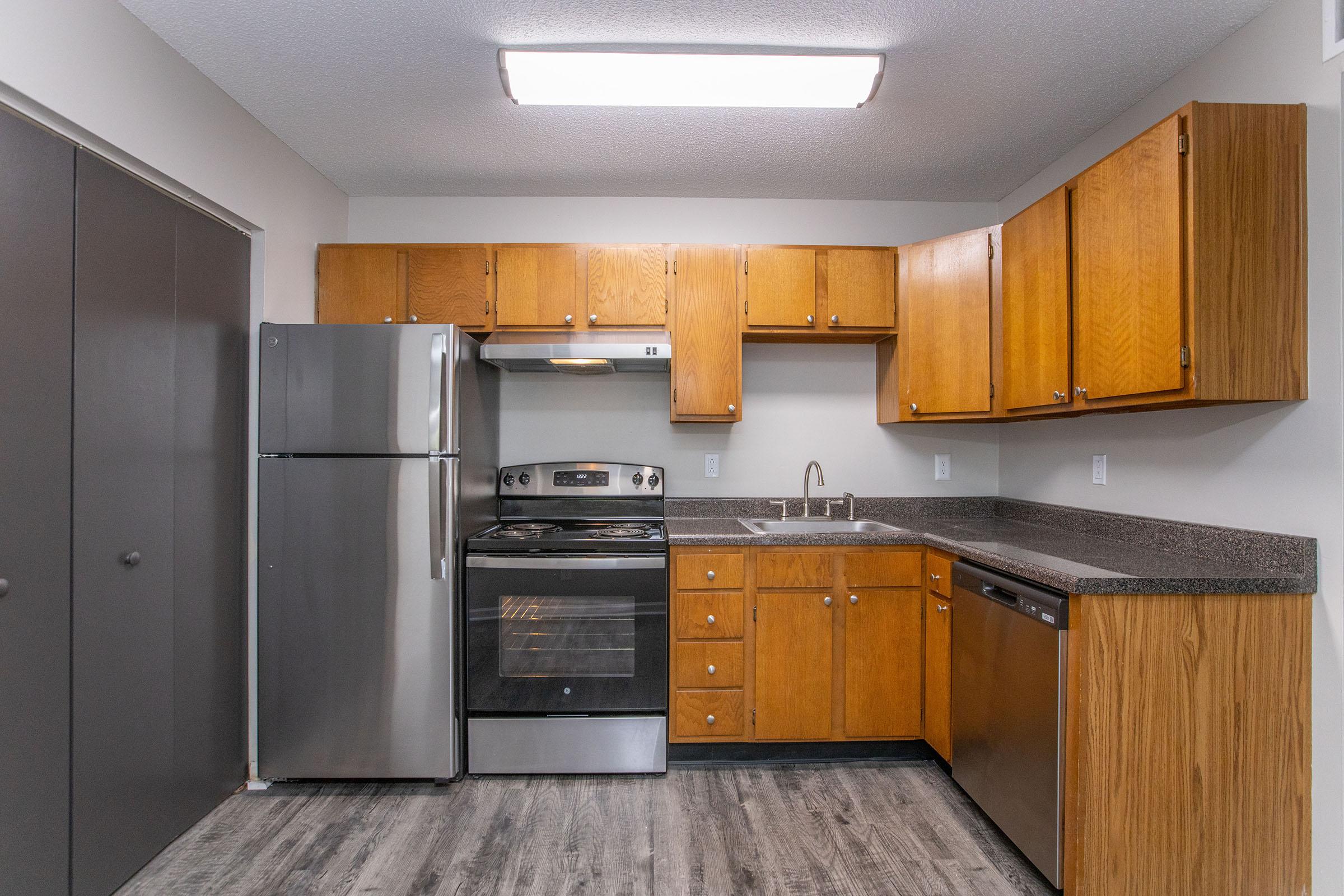 a kitchen with stainless steel appliances and wooden cabinets