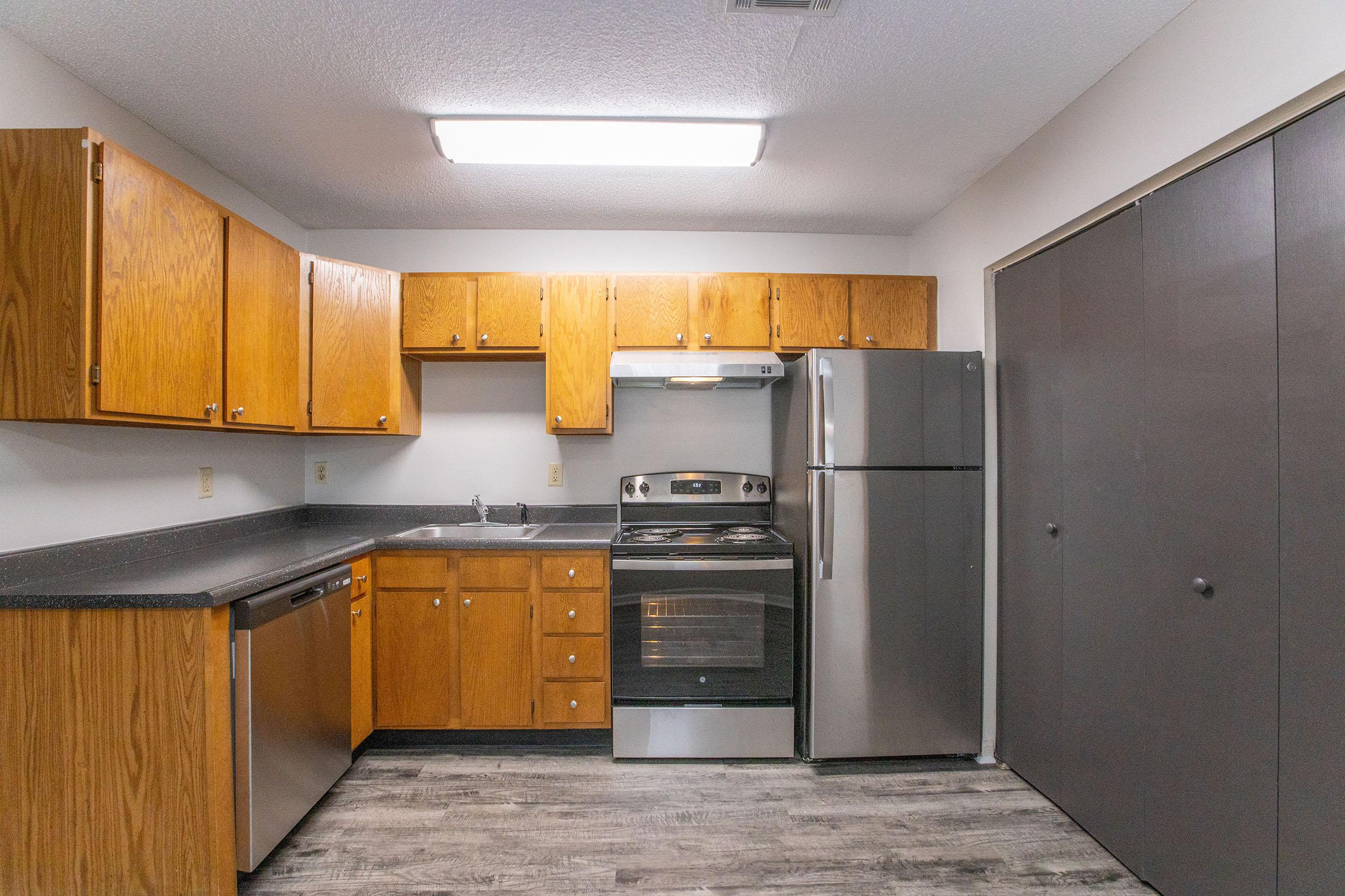 a kitchen with stainless steel appliances and wooden cabinets