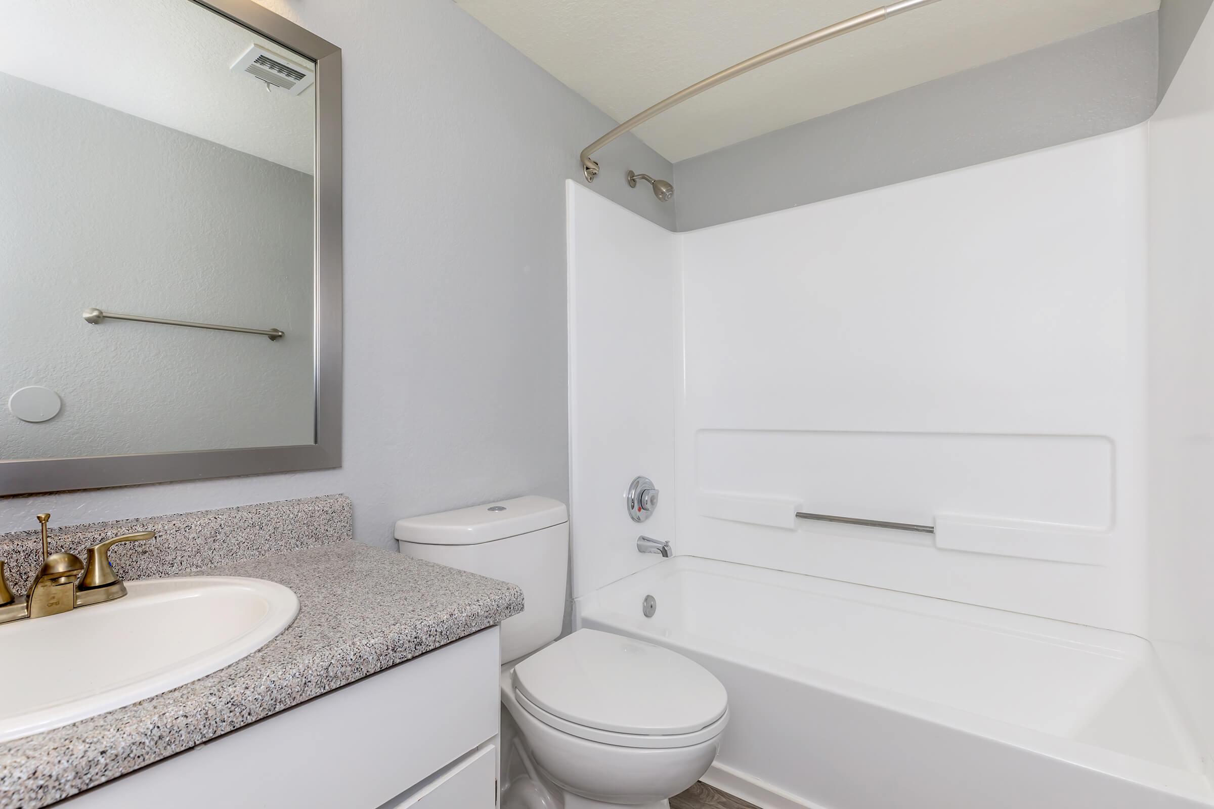 a white sink sitting under a mirror