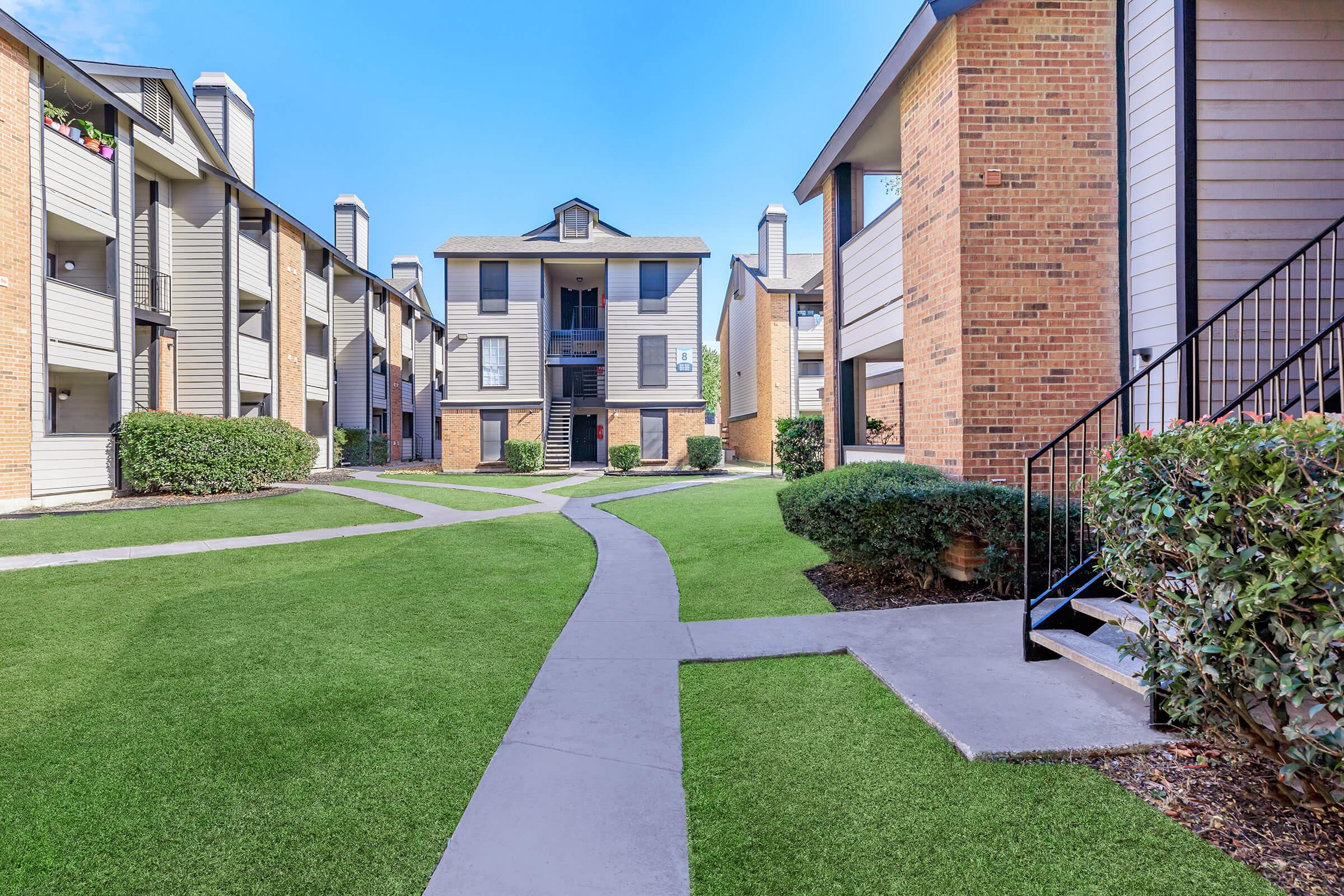 a large lawn in front of a brick building