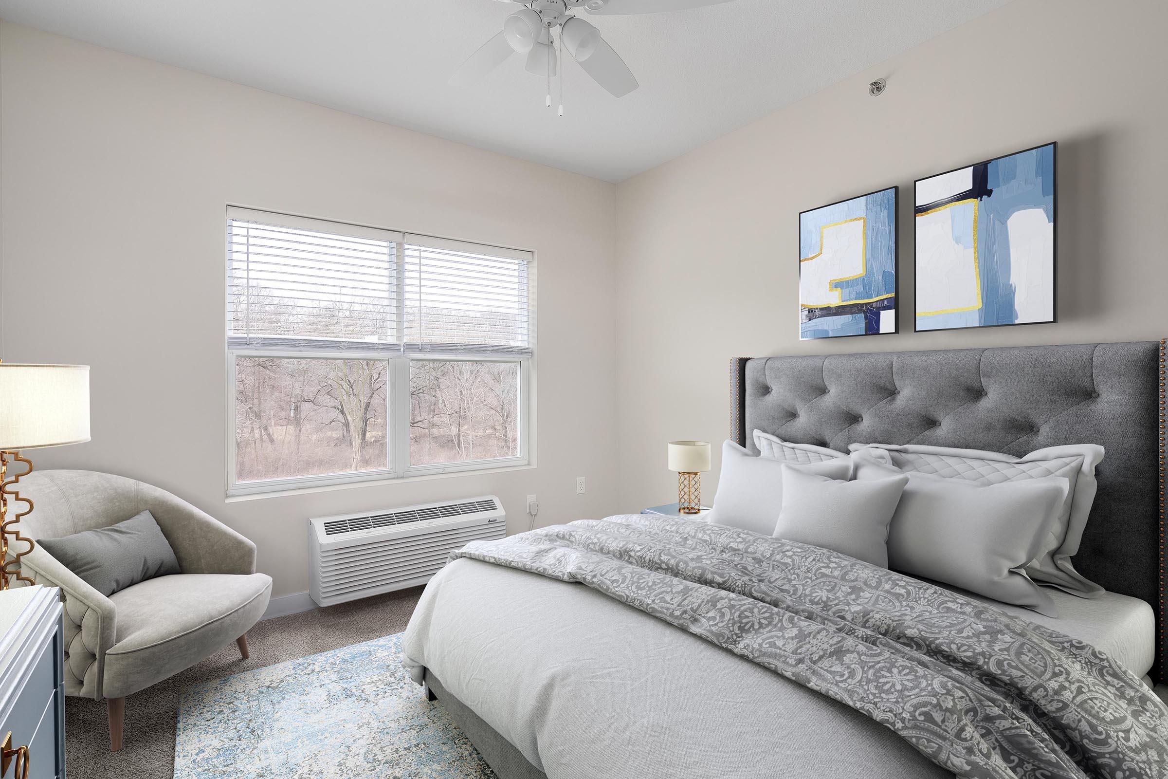 a bedroom with a bed and a chair in a room