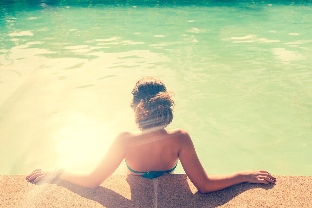 a woman sitting next to a body of water