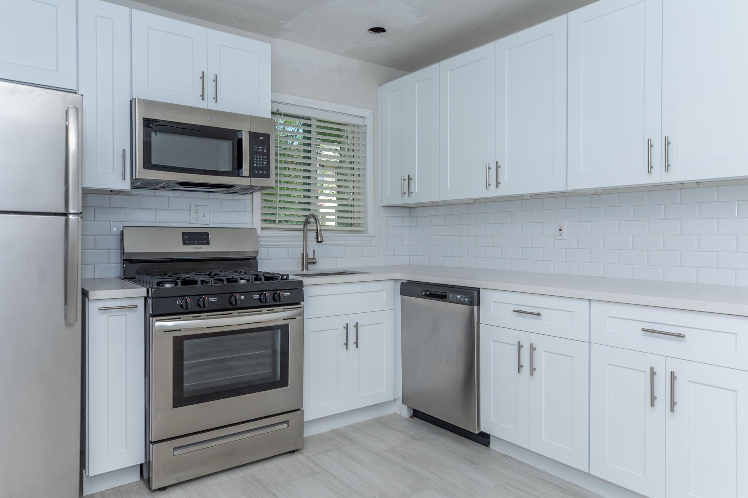 a stove top oven sitting inside of a kitchen