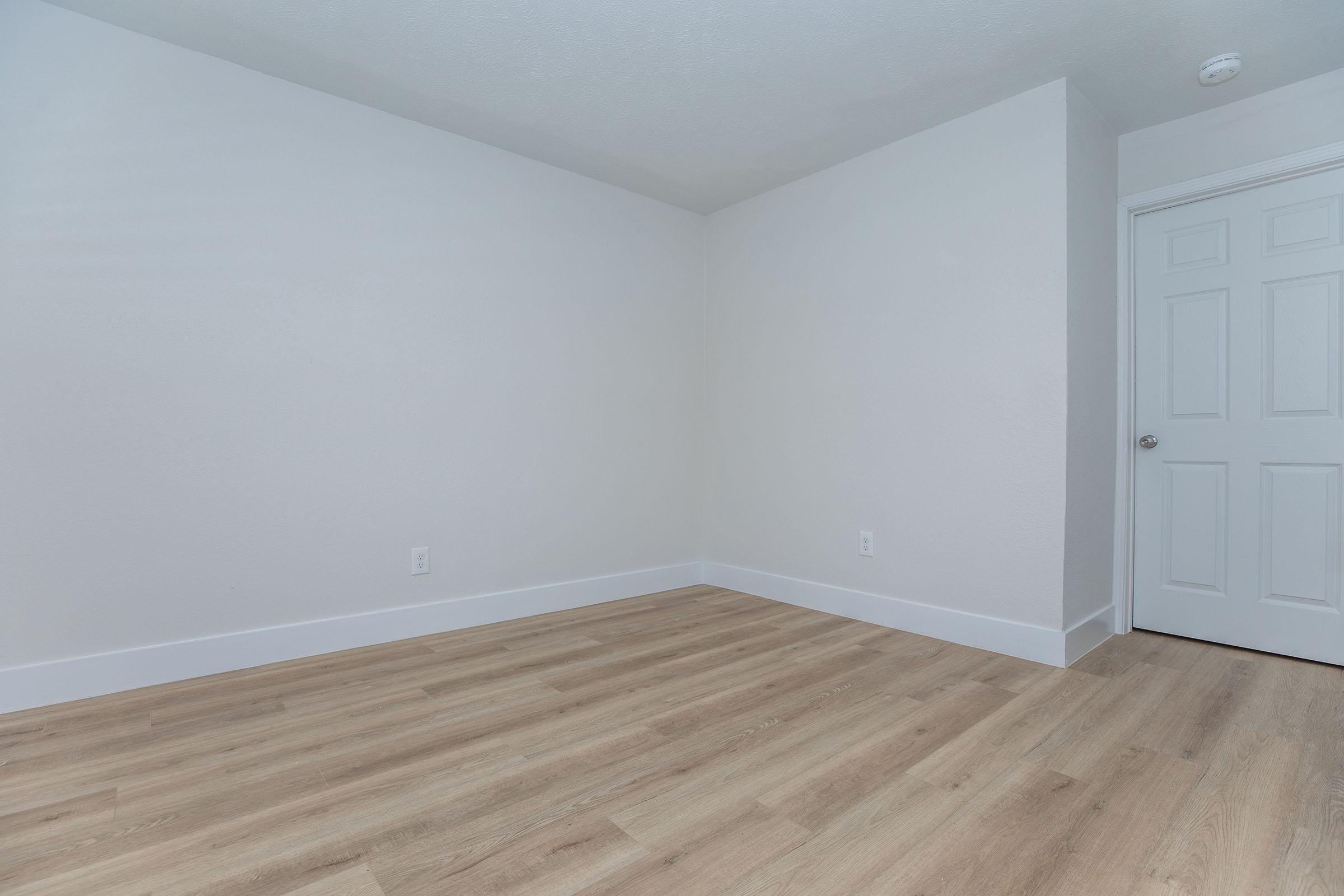 a bedroom with a wooden floor