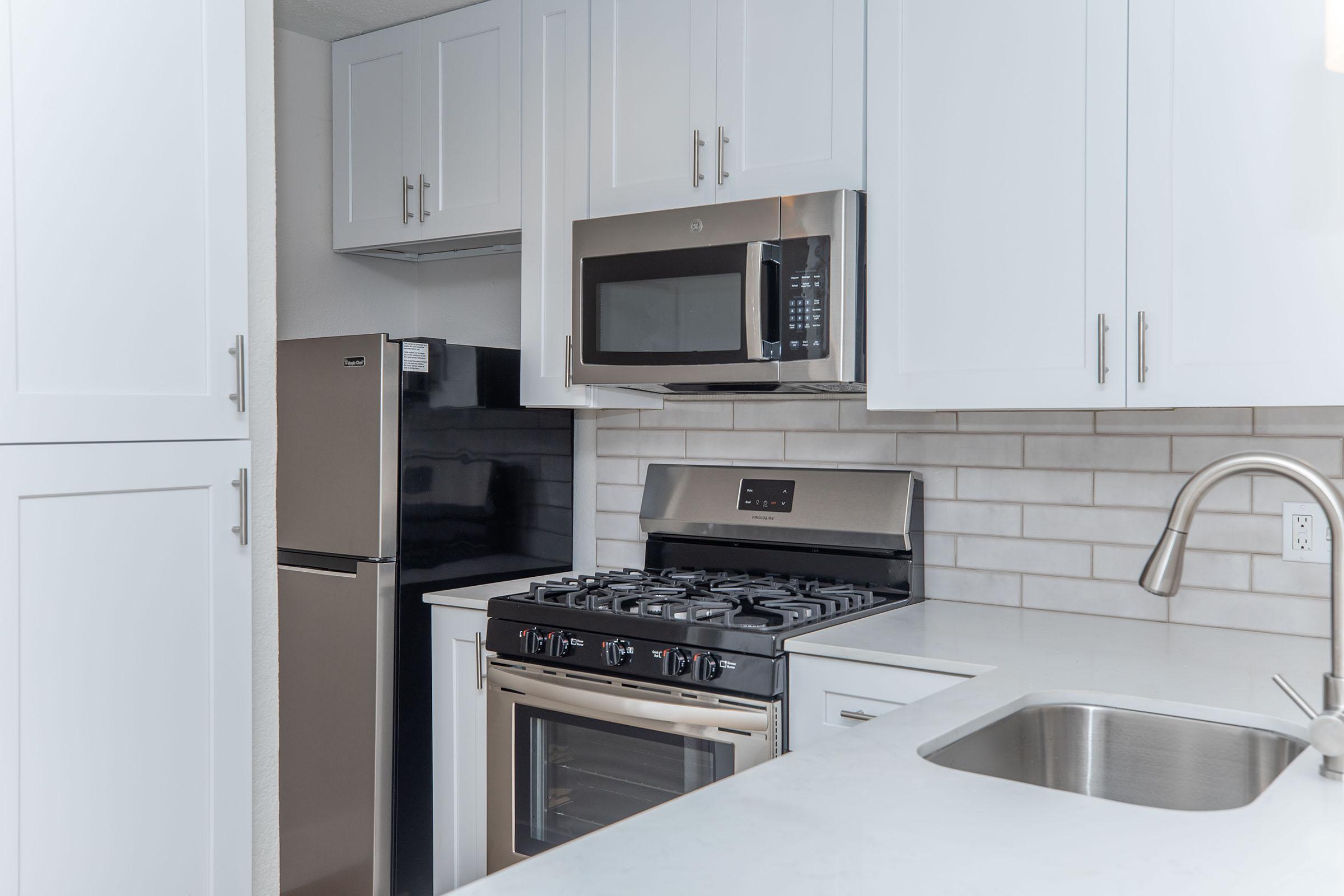 a stove top oven sitting inside of a kitchen