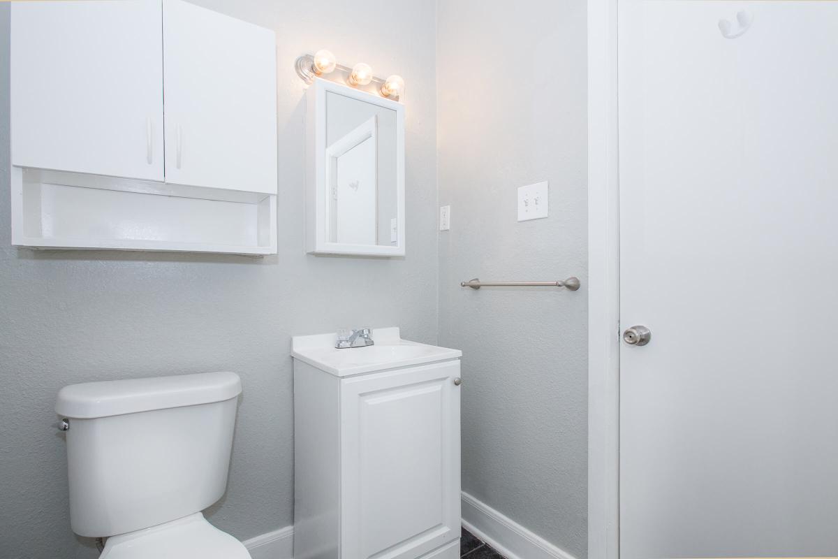 a white sink sitting under a mirror