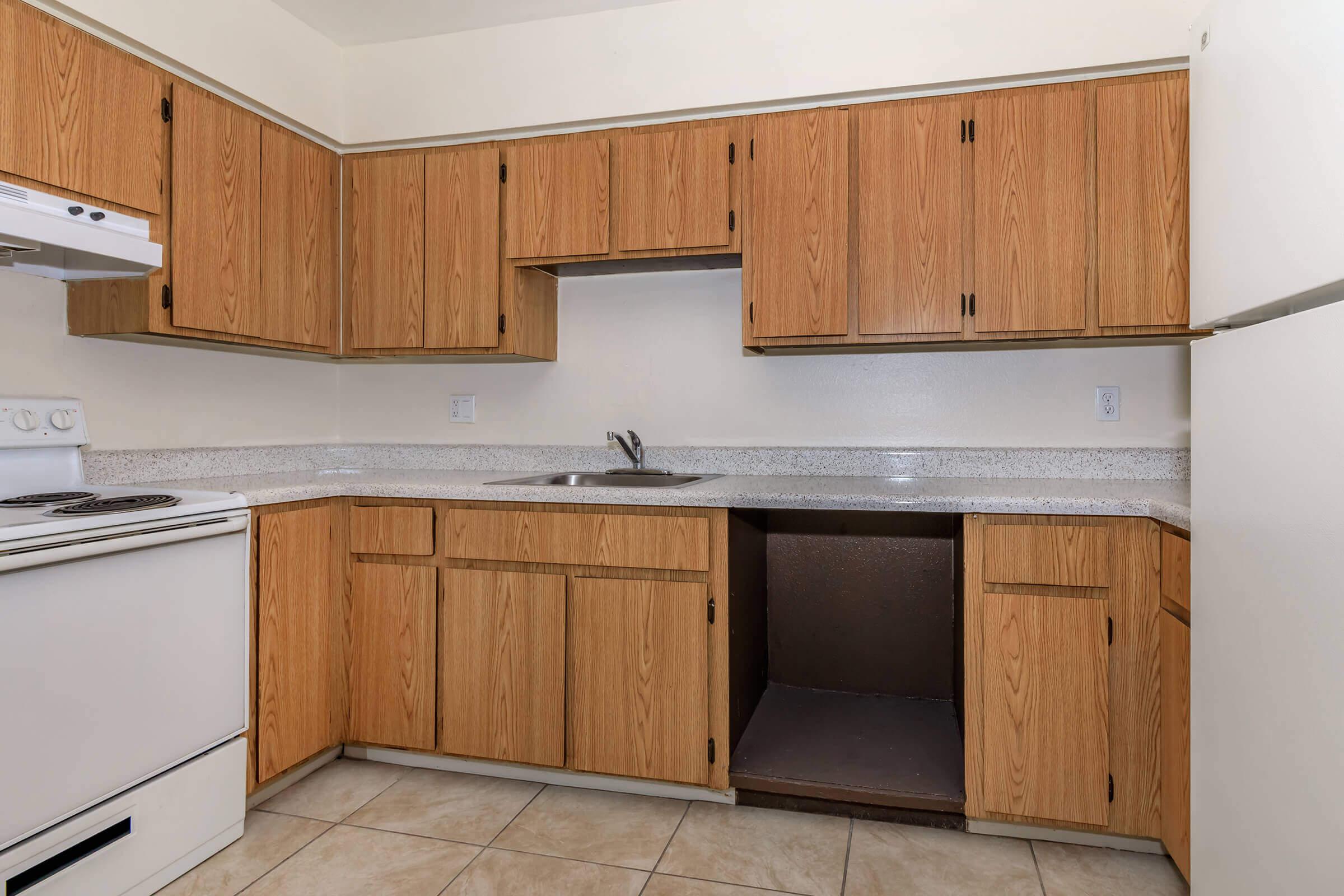 a kitchen with a stove refrigerator and wooden cabinets
