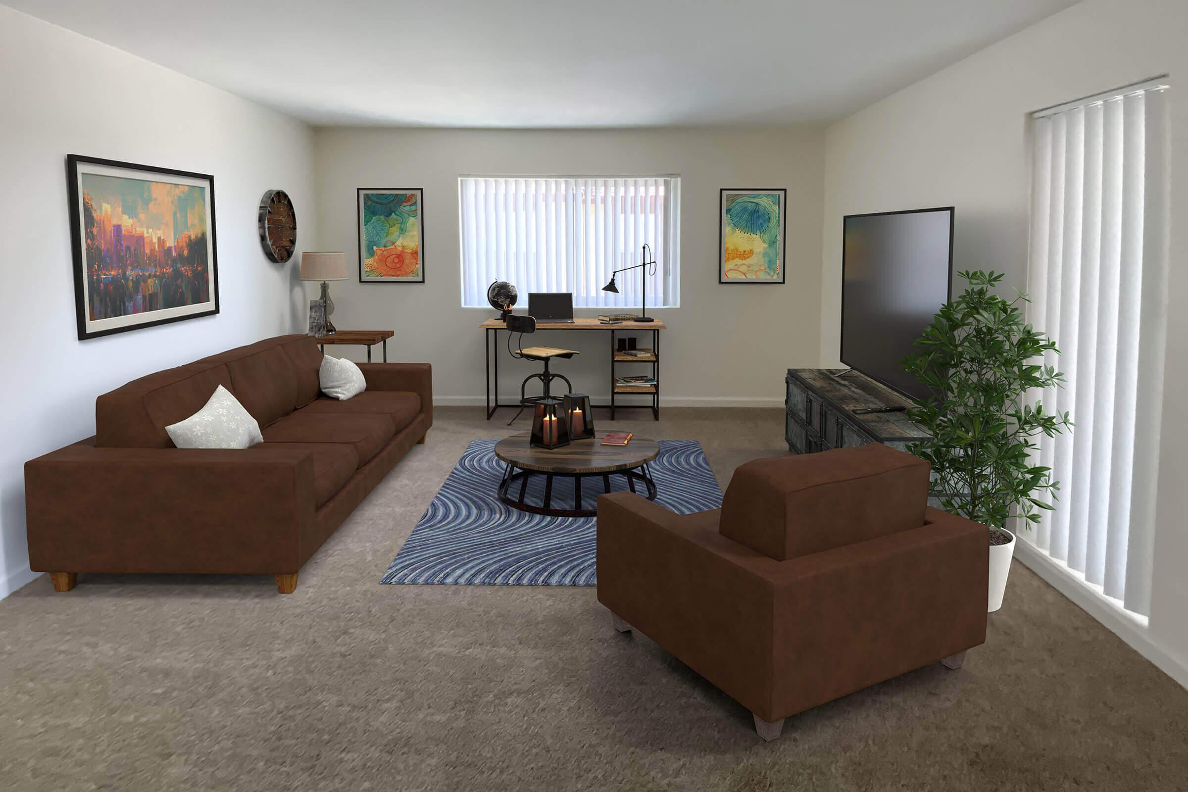 A cozy living room featuring a brown sofa and armchair, a circular coffee table with a decorative centerpiece, and a TV stand. There’s a desk with a lamp, and artwork on the walls. Natural light streams through window blinds, and a potted plant adds a touch of greenery to the space.