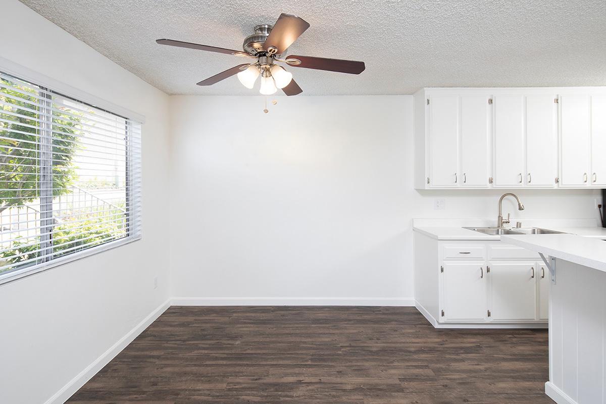 a kitchen with white cabinets and a large window