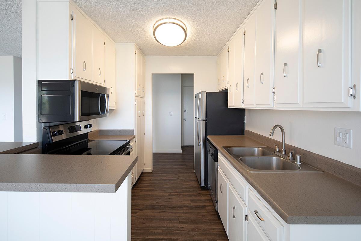 a large kitchen with stainless steel appliances and wooden cabinets