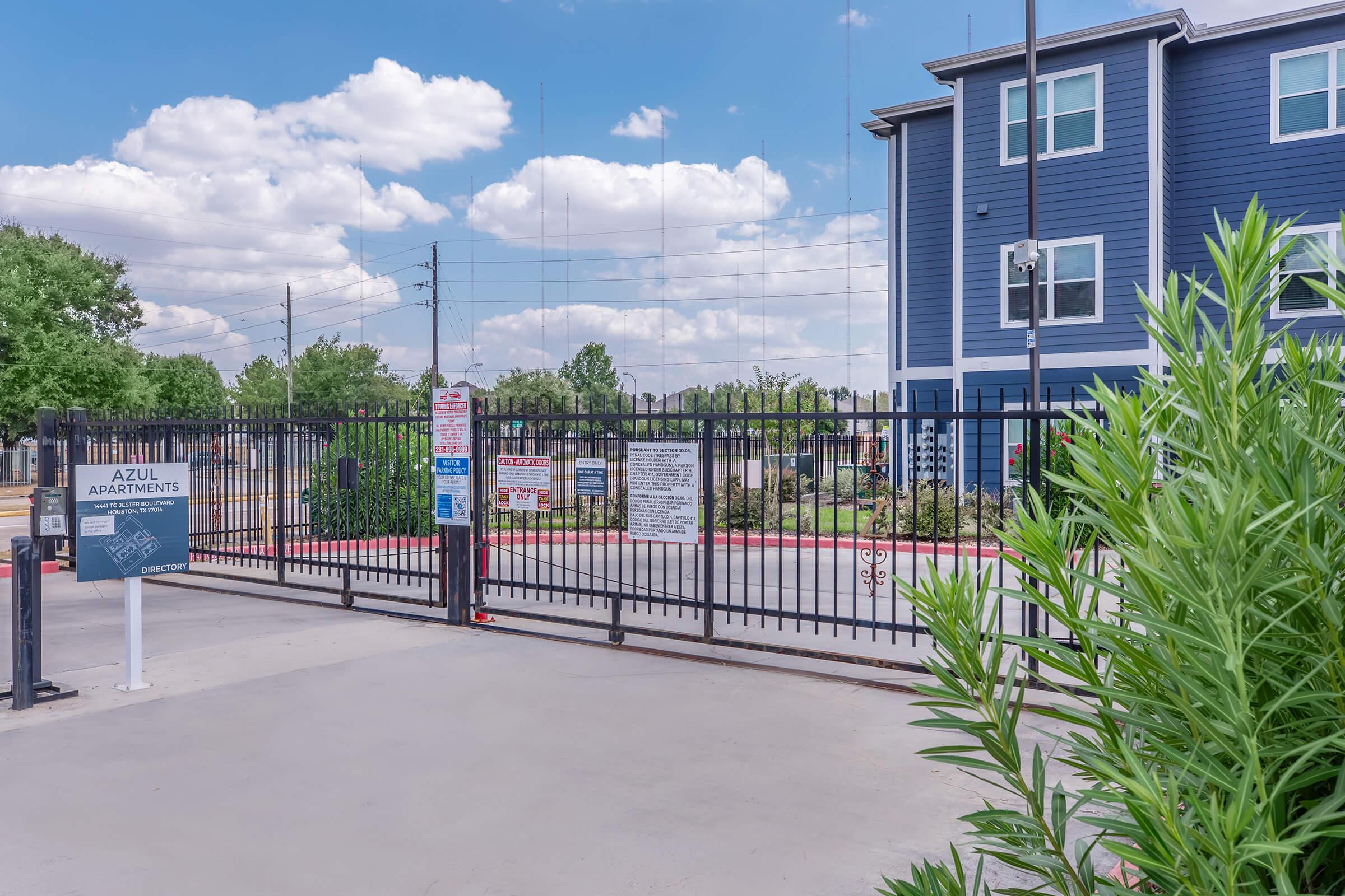 a building with palm trees and a fence