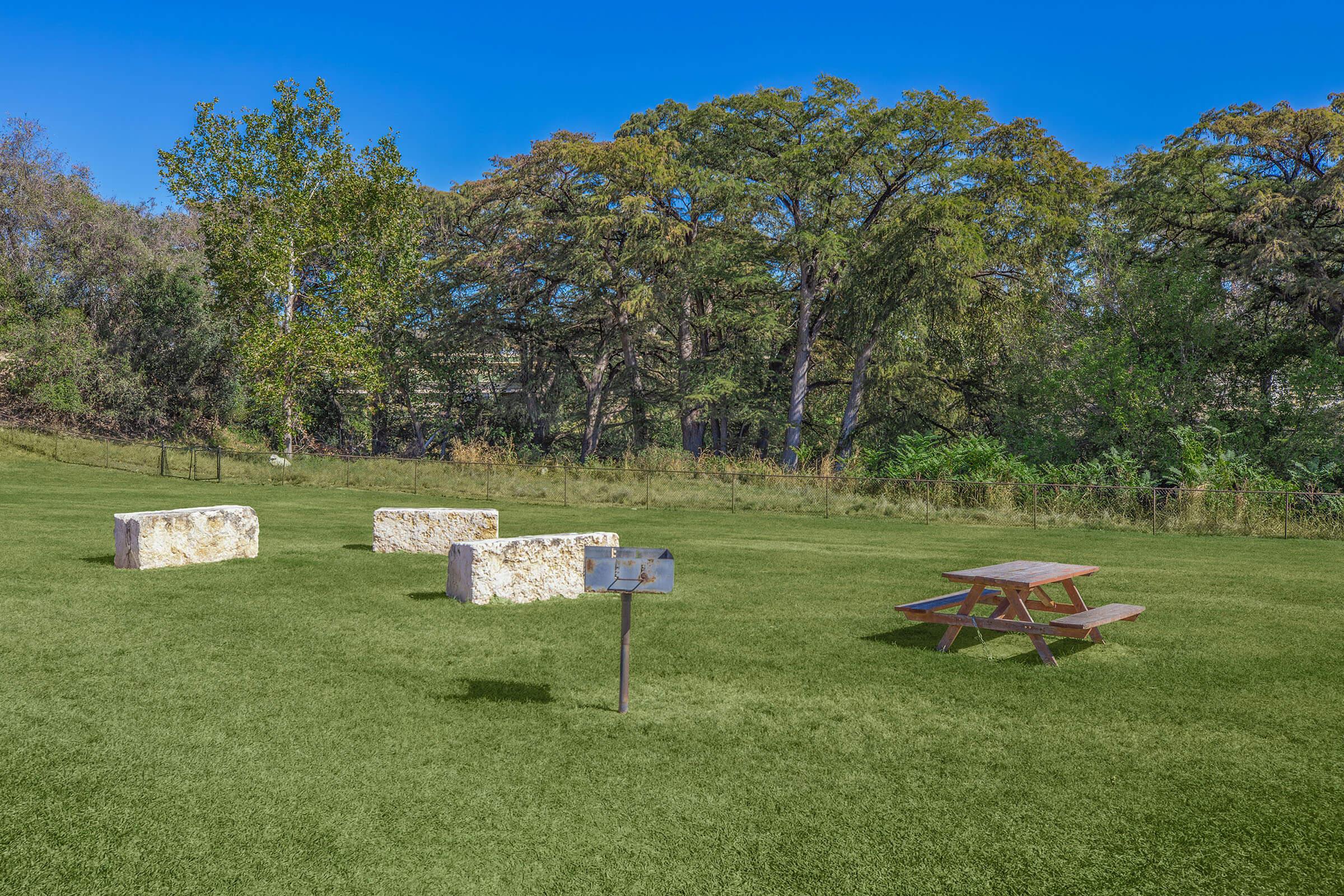 a group of lawn chairs sitting on top of a grass covered field