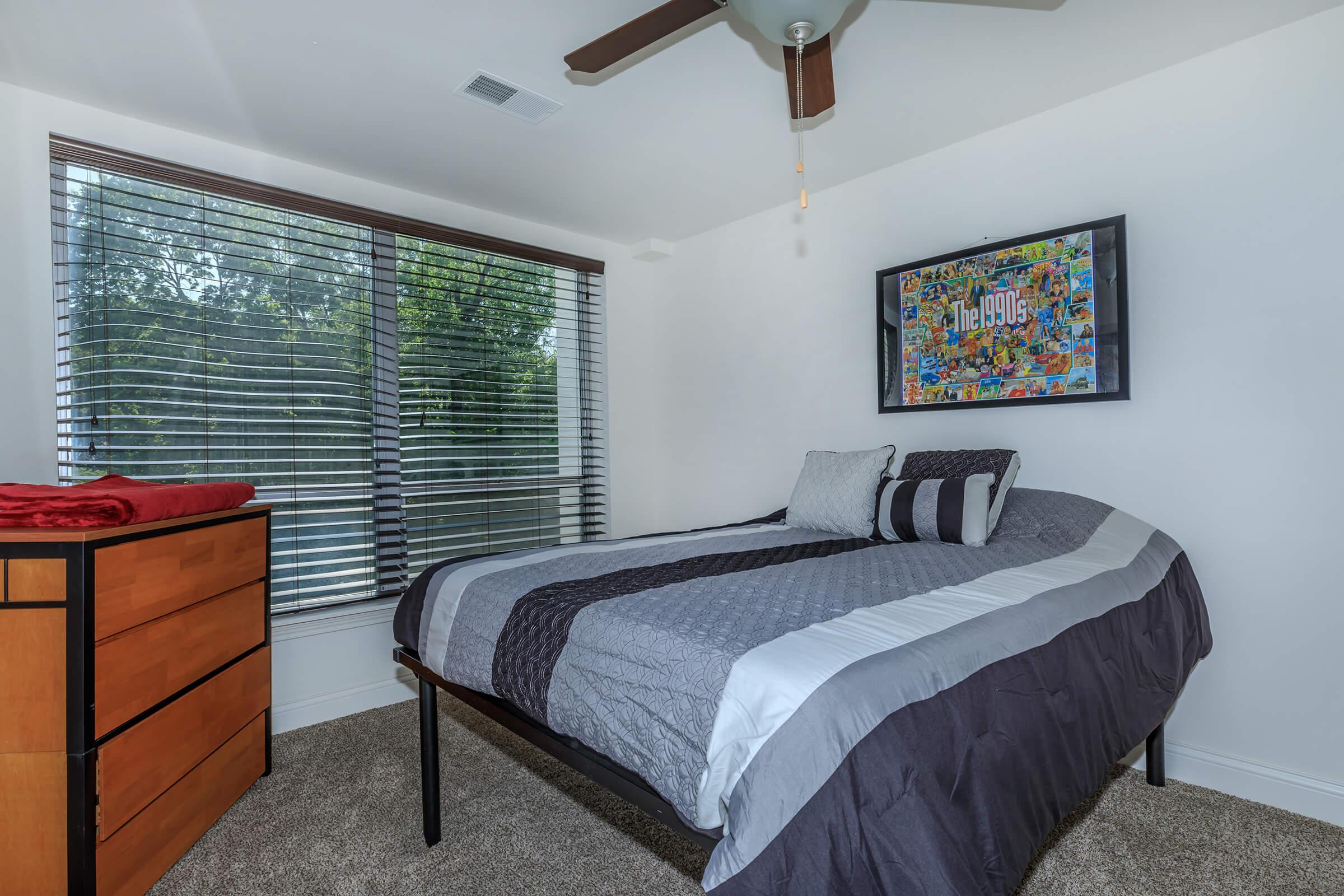 a bedroom with a bed and desk in a room