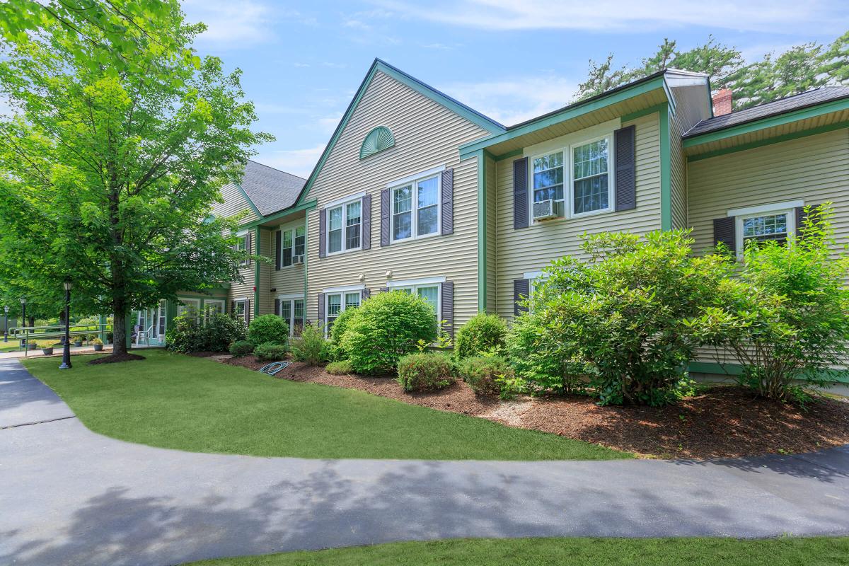 a large brick building with grass in front of a house