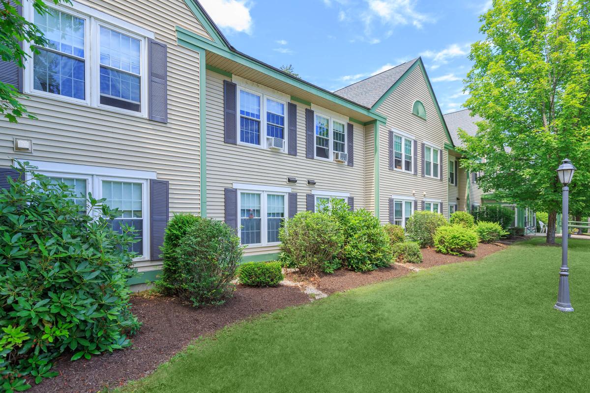 a large brick building with grass in front of a house