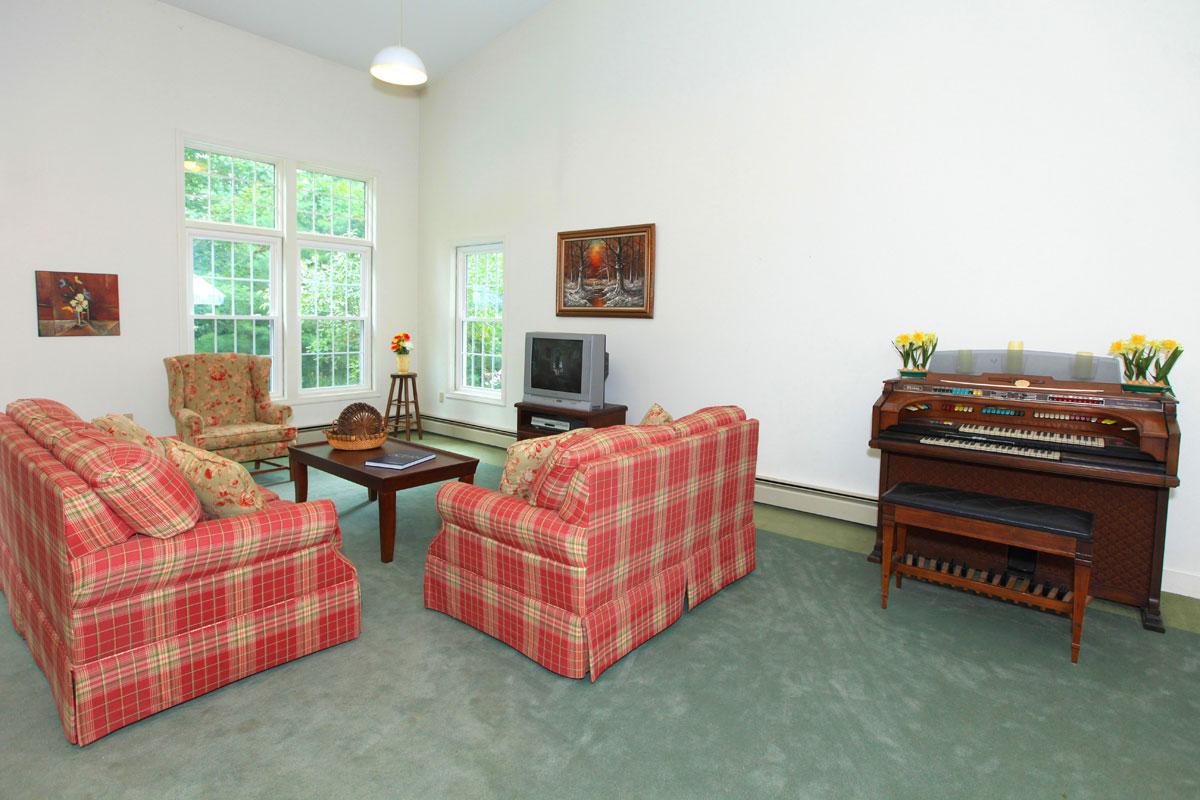 a living room filled with furniture and a red chair