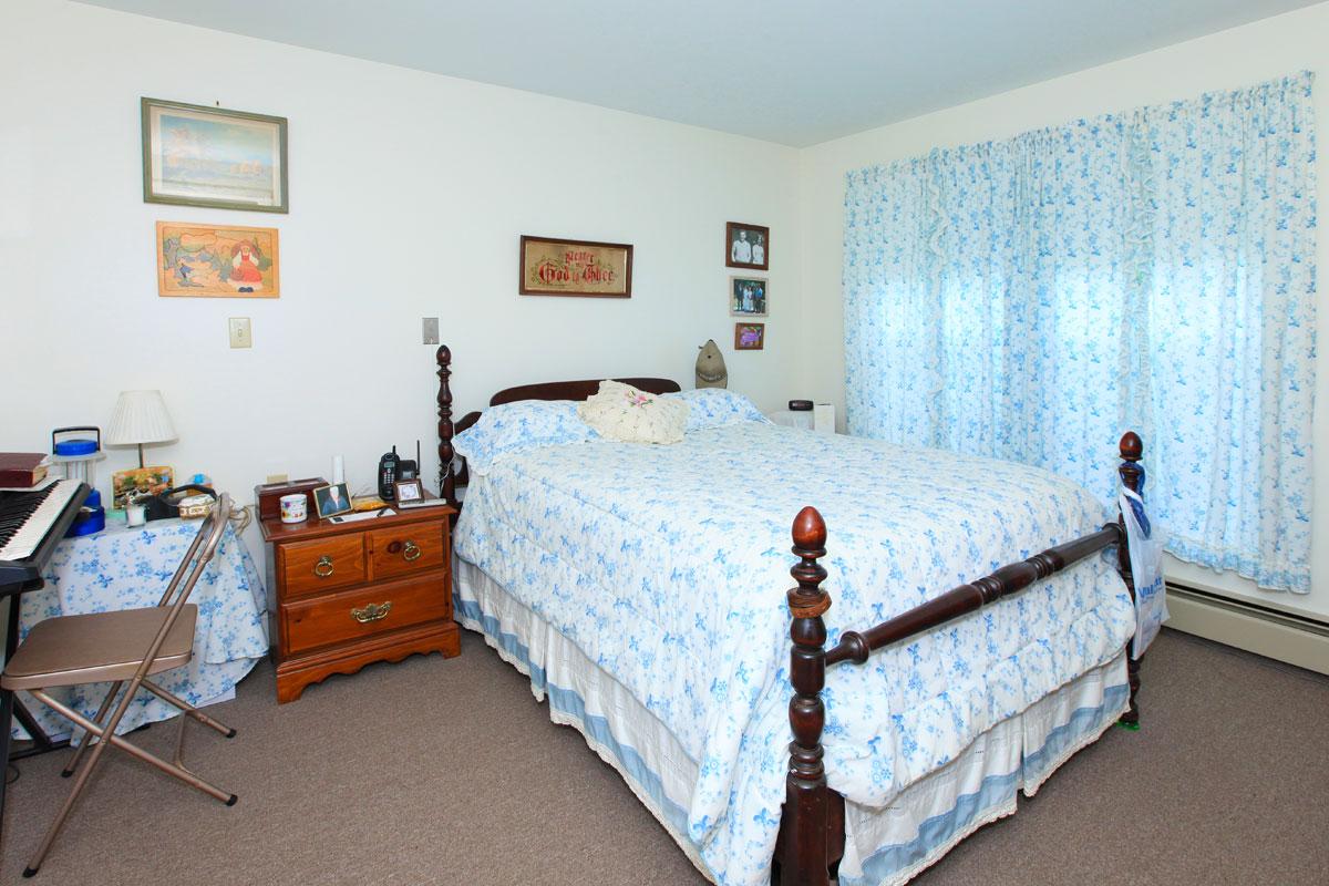 a bedroom with a bed and desk in a room