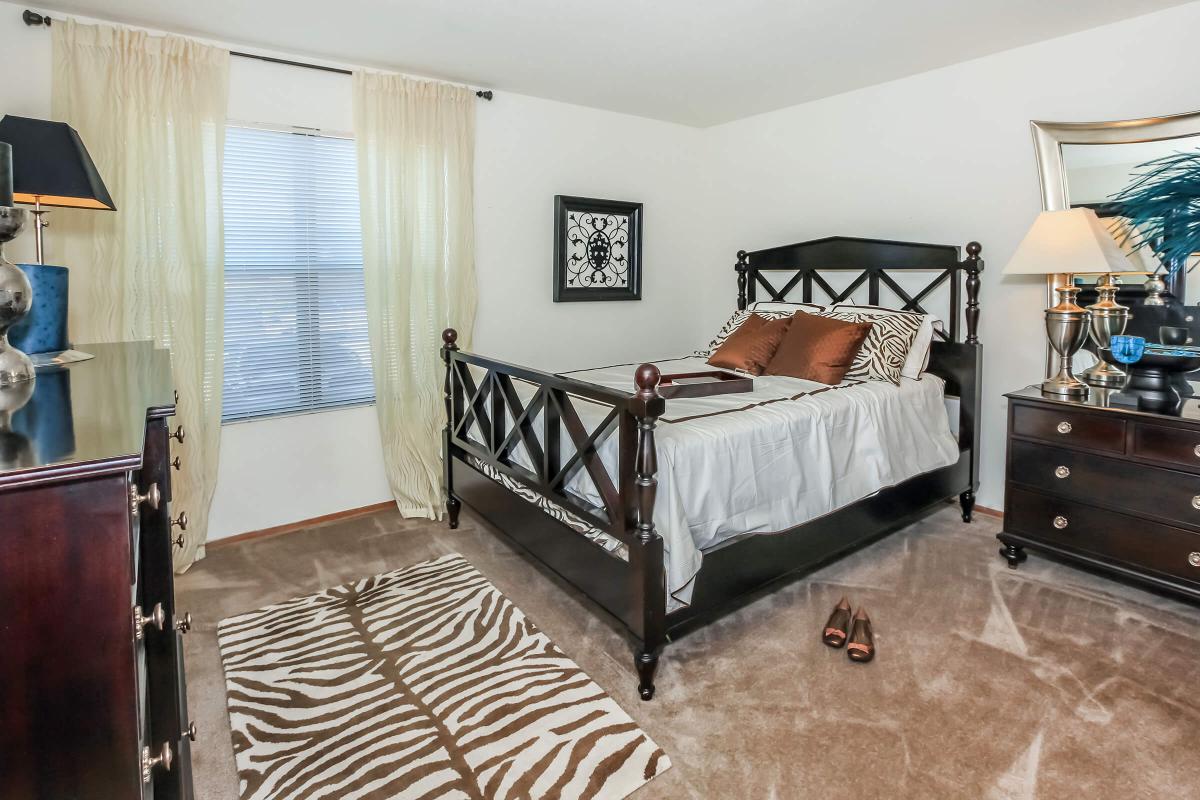 a bedroom with a bed and a chair in a room