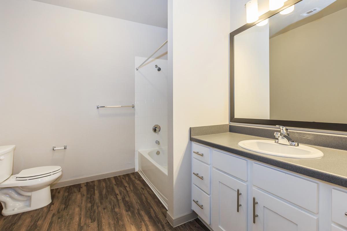 a white sink sitting under a mirror