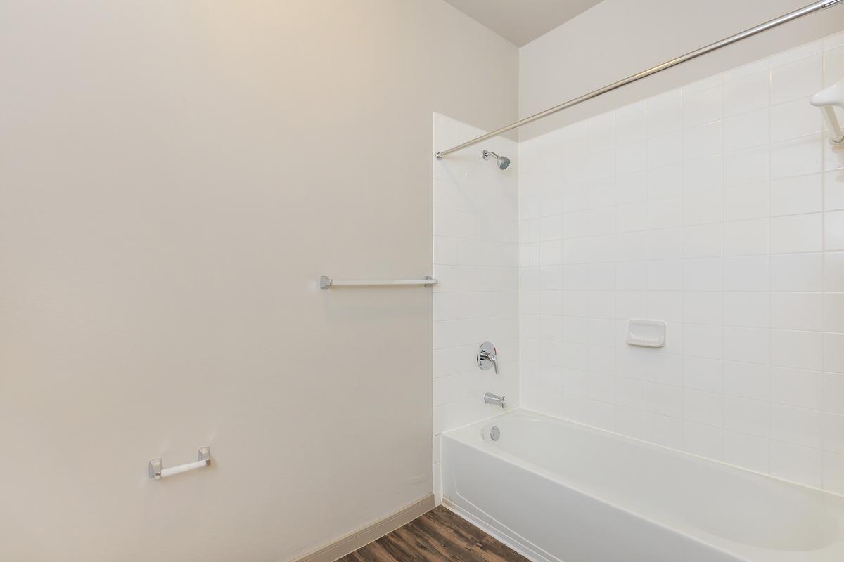 a white tub sitting next to a shower