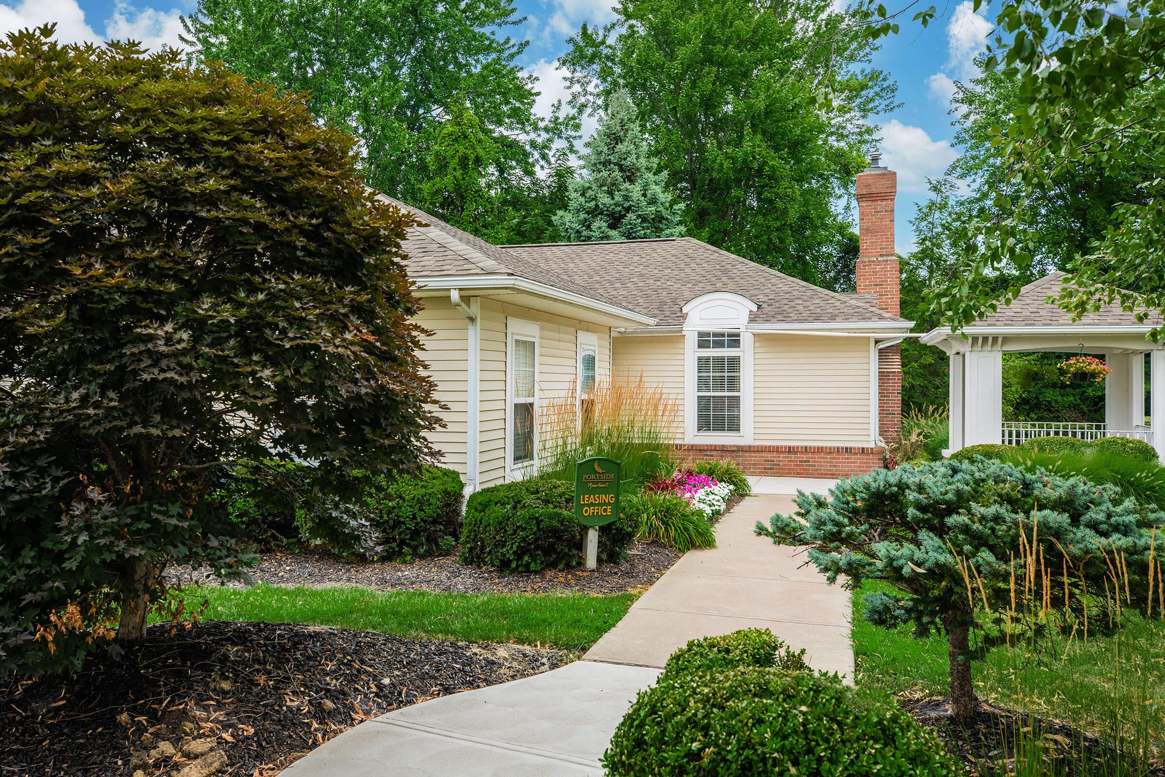 a house with bushes in front of a brick building