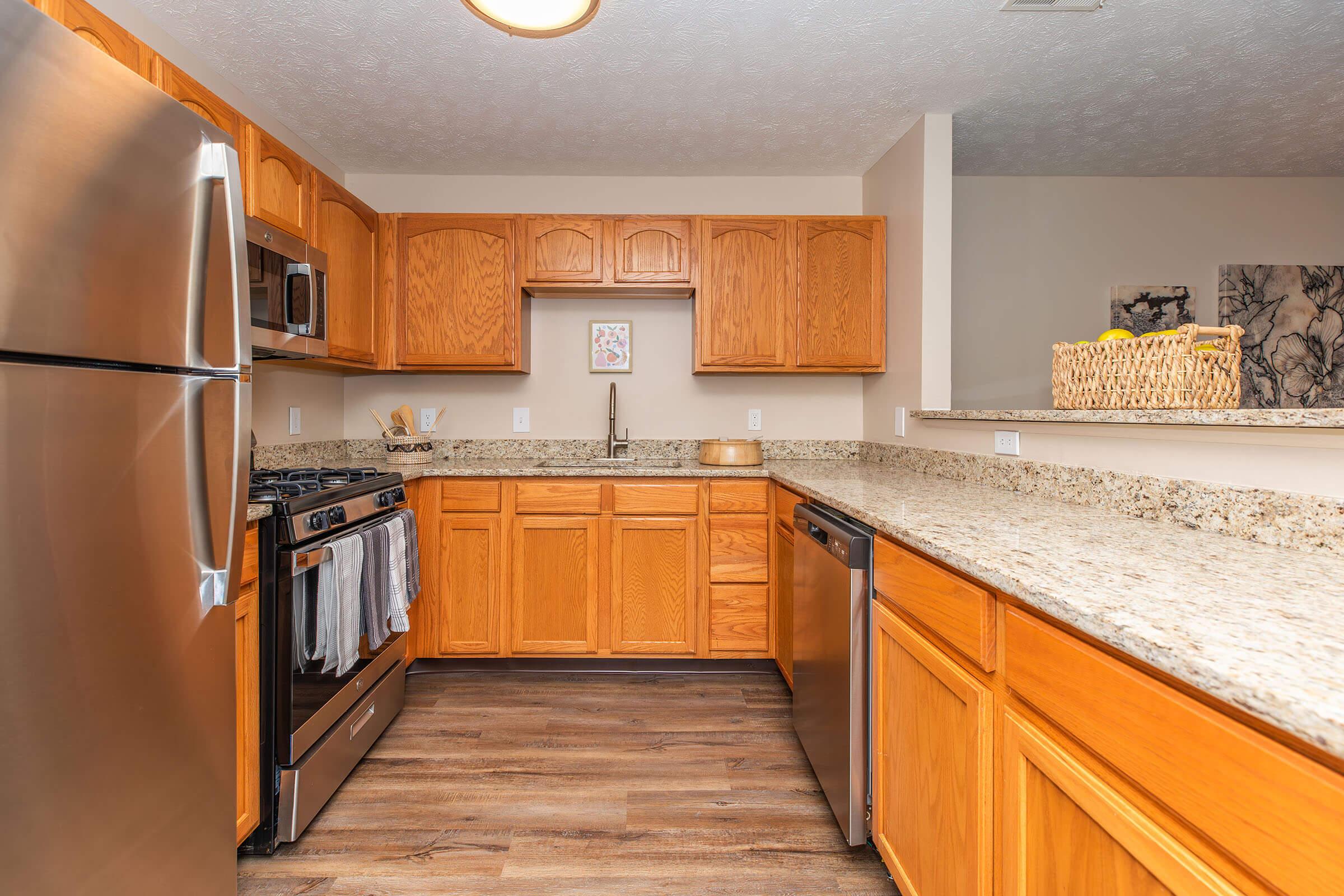 a large kitchen with stainless steel appliances and wooden cabinets