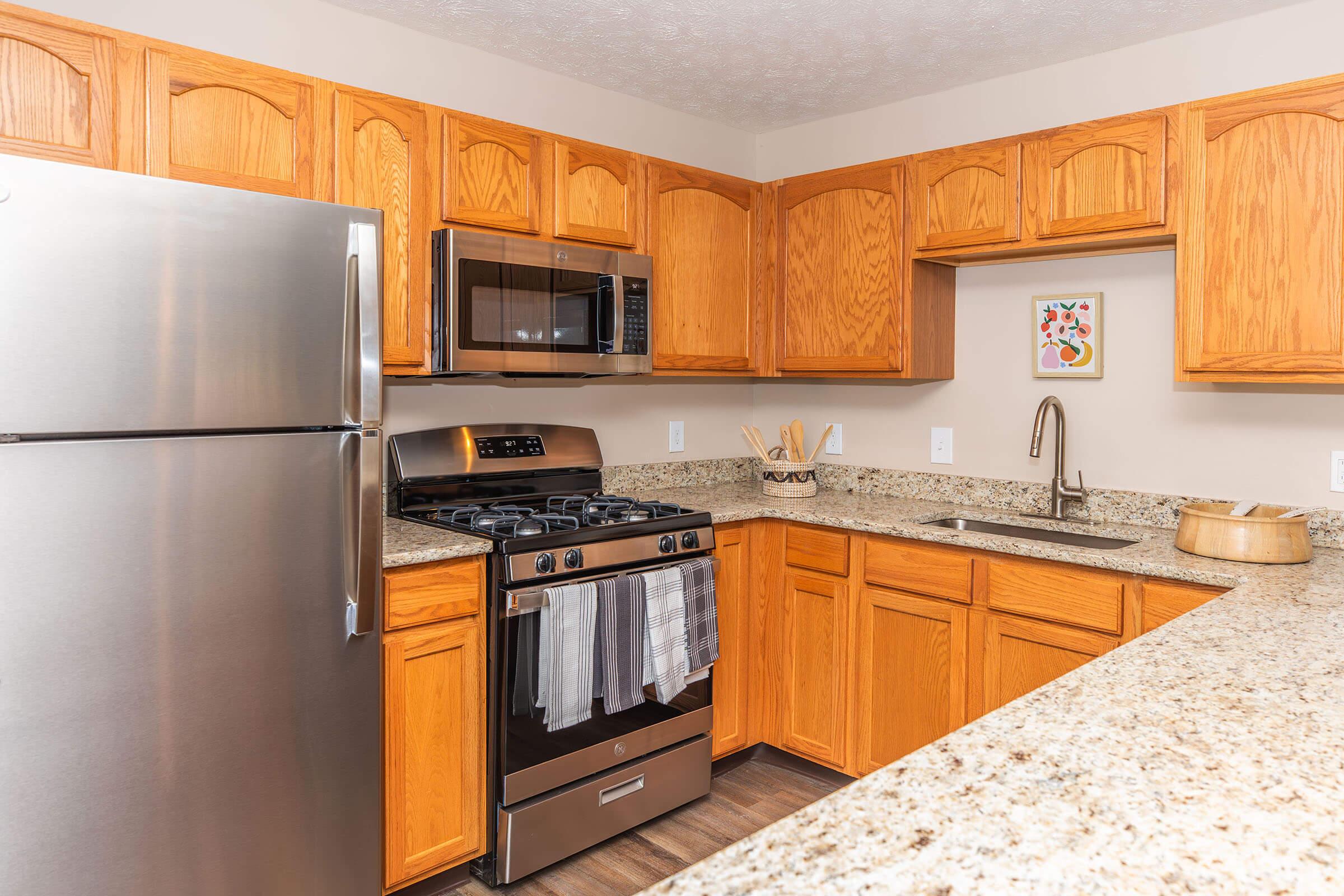 a kitchen with stainless steel appliances and wooden cabinets