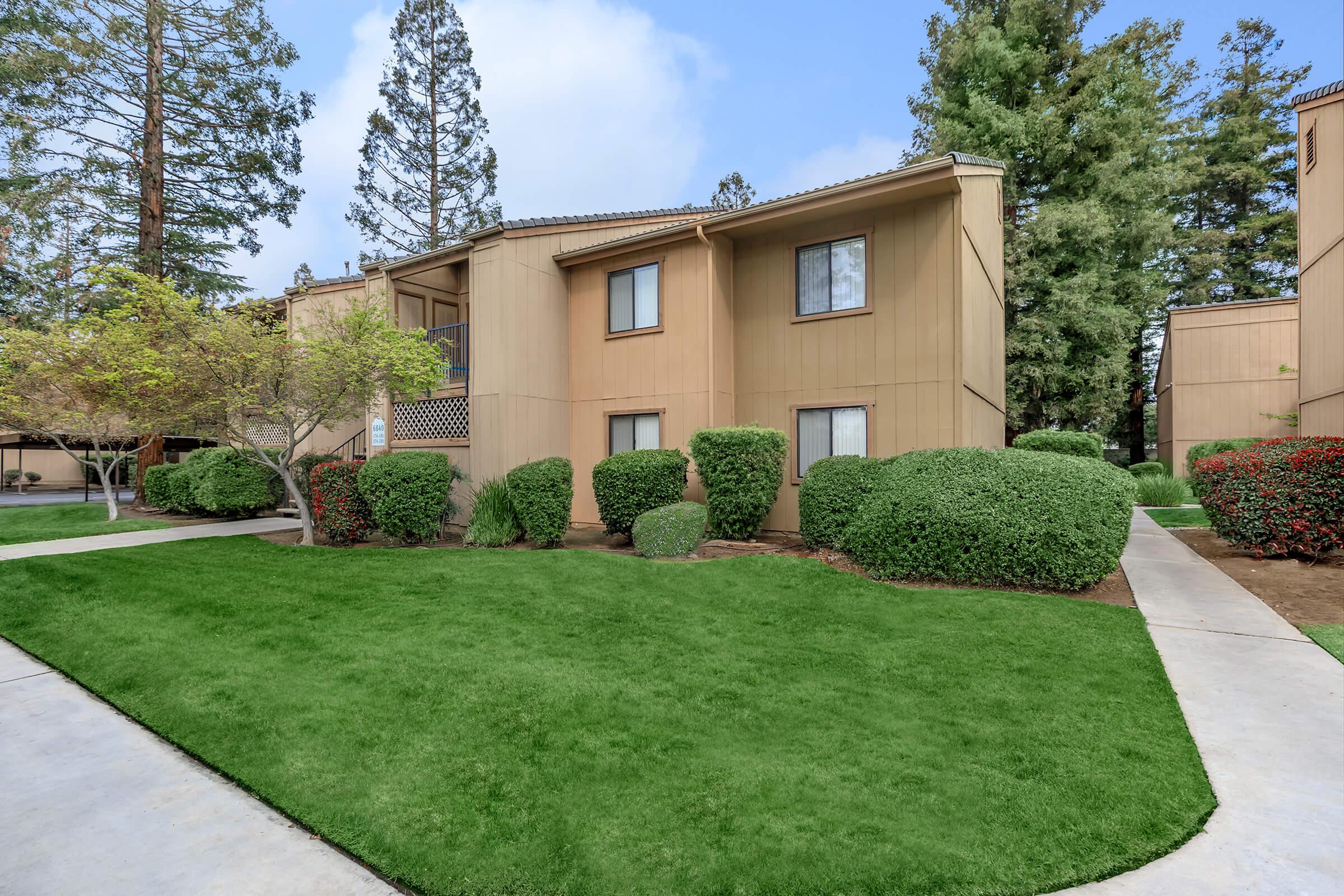 a large lawn in front of a brick building